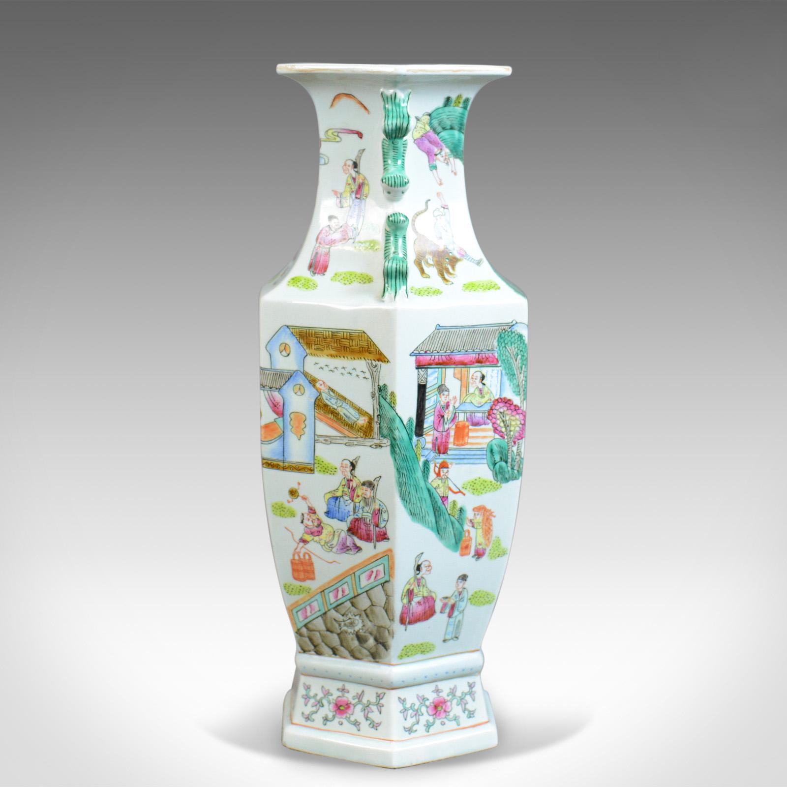 This is a midcentury hexagonal baluster vase, a 20th century, Chinese ceramic urn. 

Attractive Chinese baluster vase
Profusely decorated from neck to base
Free from any damage or marks
Unmarked base

Street scene with shops, figures and
