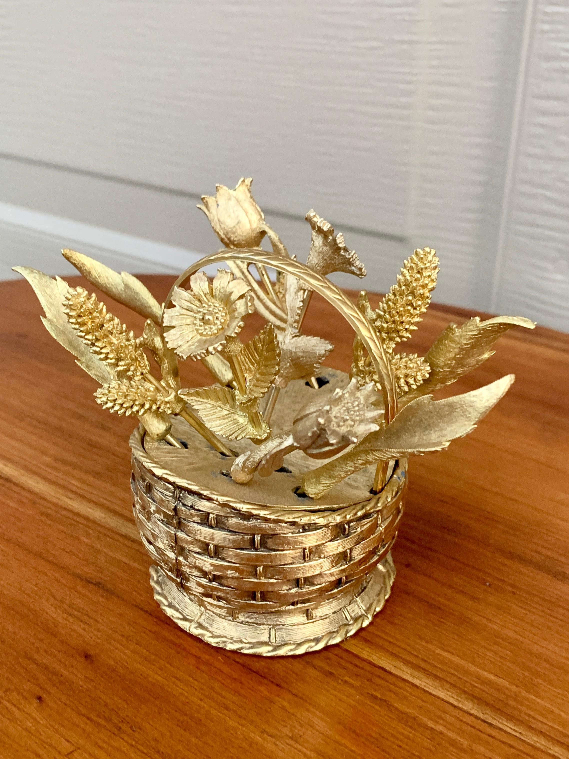 A charming mid-century Hollywood Regency cocktail pick or toothpick holder fashioned as a woven basket and flower picks.

USA, Circa 1960s

Cast gold plated metal

Measures: 4