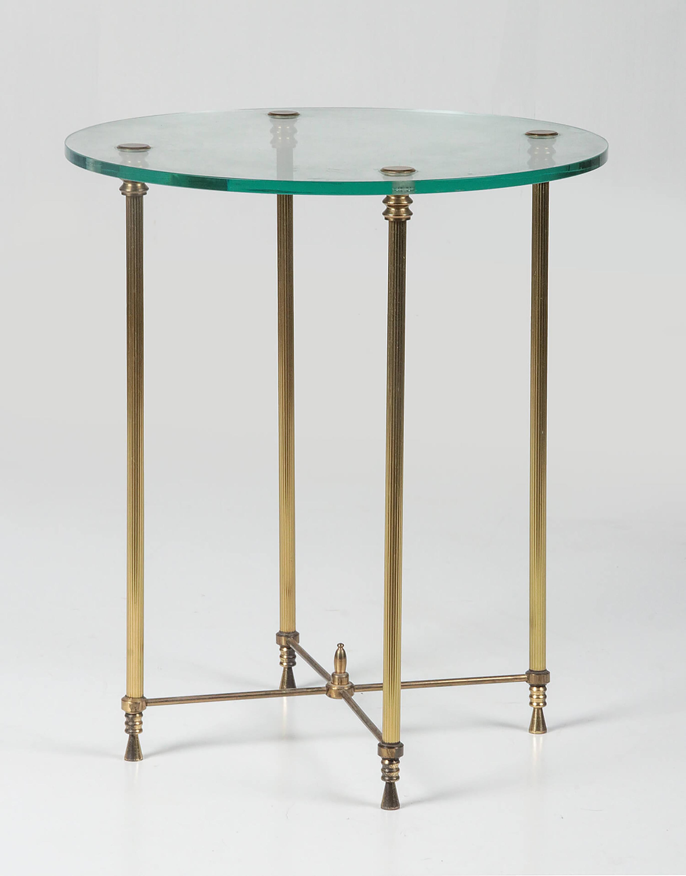 Elegant and graceful side table. It is a round model with a glass top and a copper base. The copperwork has fluted legs. The table is in good condition.