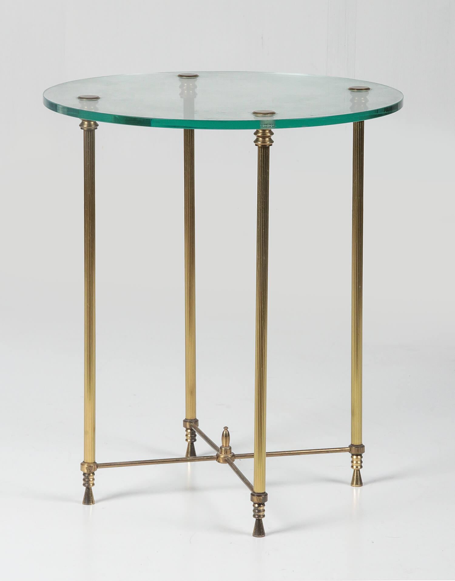 Elegant and graceful side table. It is a round model with a glass top and a copper base. The copperwork has fluted legs. The table can be shipped safely, it is disassembled for that.