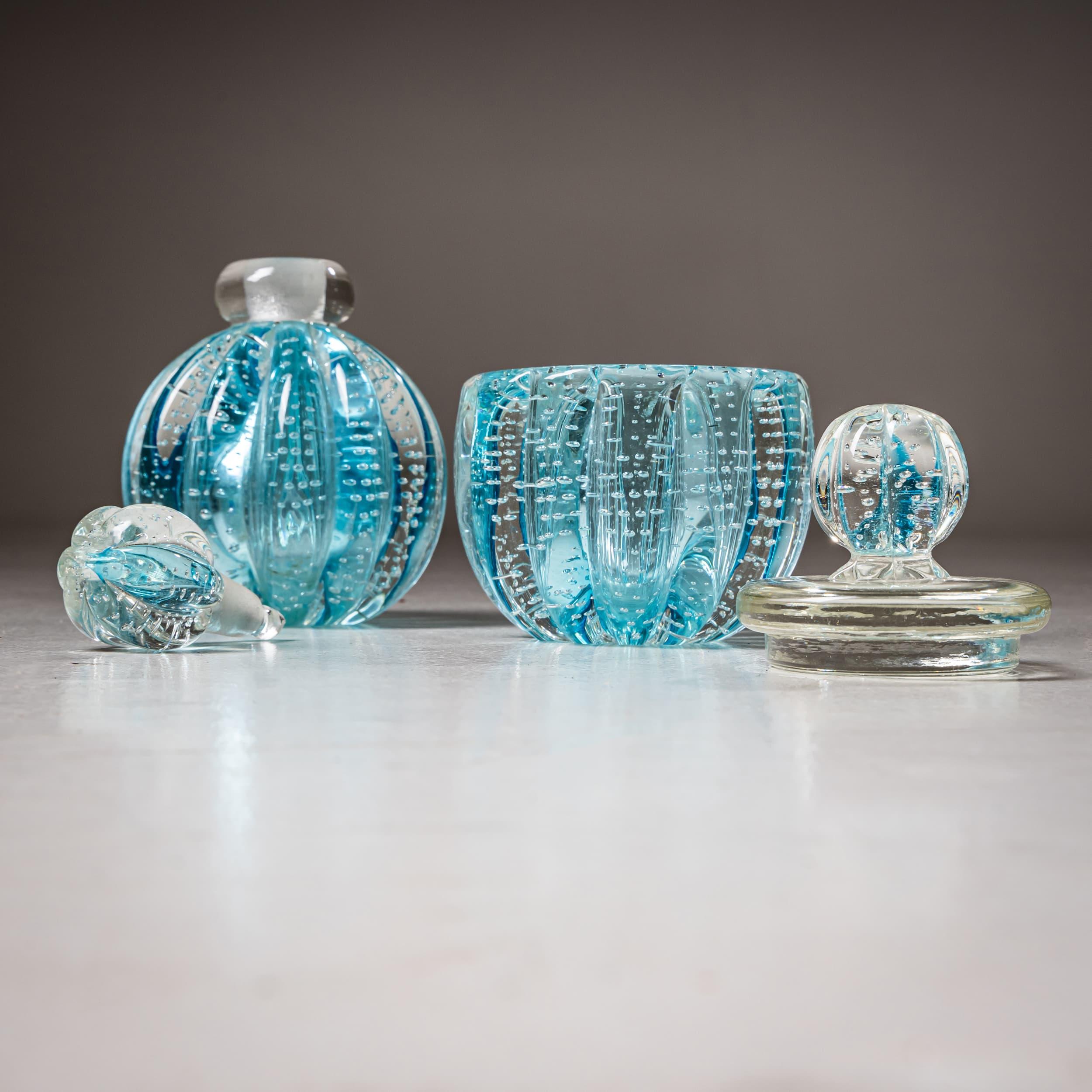 Pair of elegant bottles in turquoise Murano glass, crafted in the Hollywood Regency style. The bulbous vessels feature a ribbed surface with decorative air bubbles that lend the glass a distinctive vibrancy.