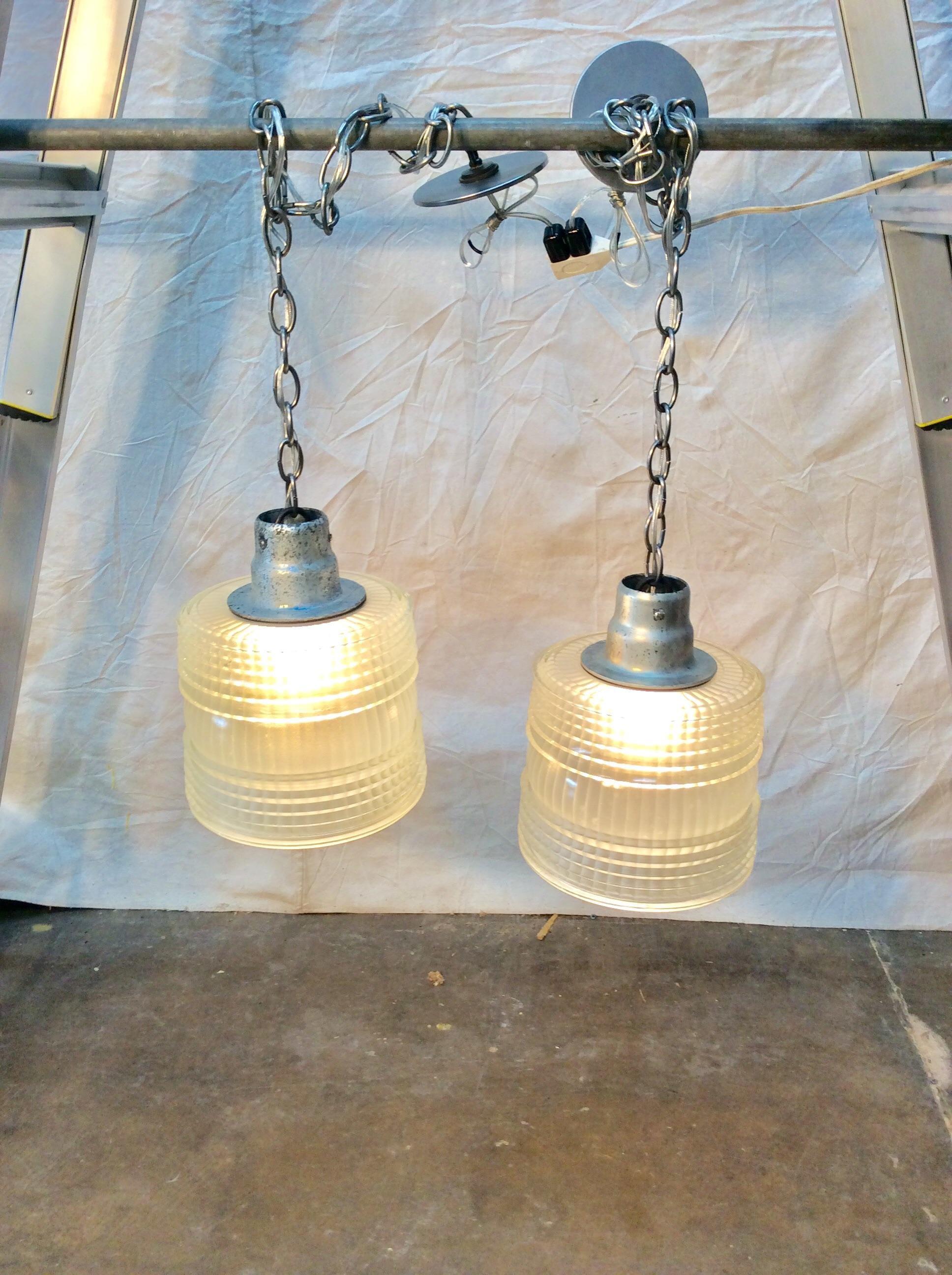 With a simple clean design these French holophane pendant lights are perfect for a kitchen or hallway. The prismatic shade and cast metal hardware is marked 3337-4, Made in France. Newly wired to United States standards the pendants are modern and