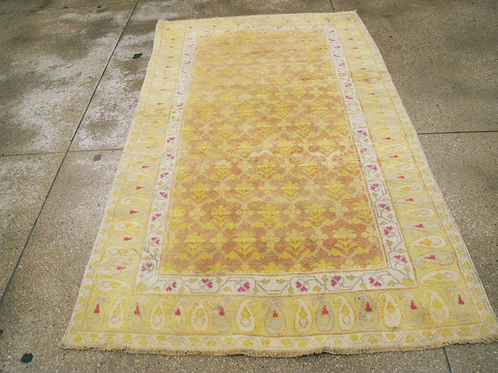 Un tappeto vintage in cotone indiano Agra. Un reticolo in stile Mughal mostra semplici palmette gialle sul campo marrone medio e variegato di questo spargimento di cotone dell'India settentrionale. Il bordo principale in paglia chiara presenta boteh