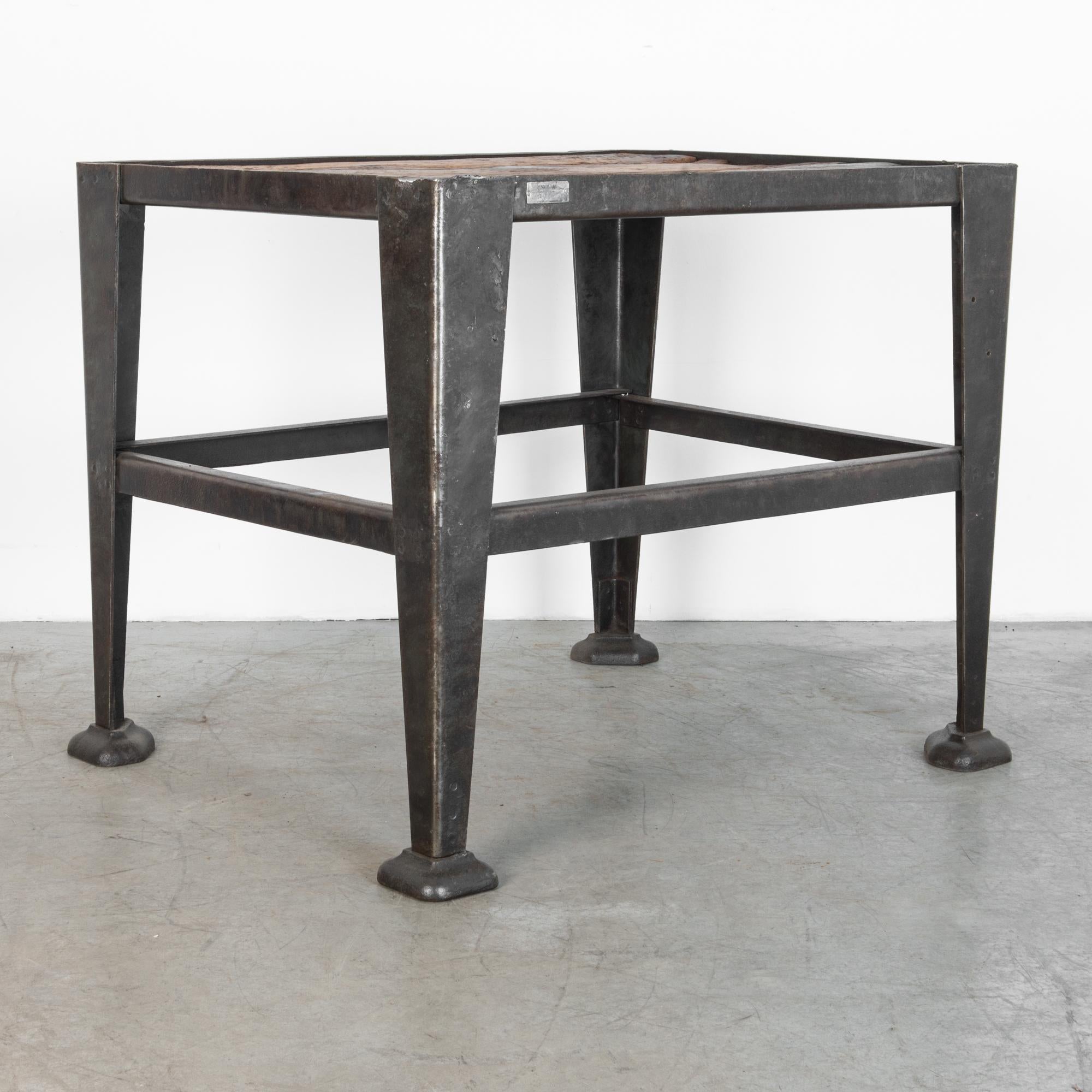 Produced in Czech Republic, circa 1950. This sturdy functional table is made of bended steel legs, and frame, topped with a rusty wood top. With many years as an industrial work surface, the table top has a great worn patina, in dark brown,