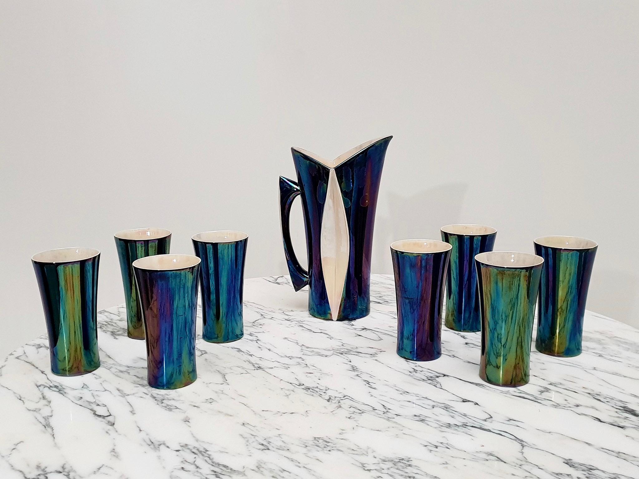 Beautiful and rare 1950s-1970s Hollywood regency iridescent drink set composed of a jug and eight glasses in enameled ceramic, made in France (possible by Vallauris), a potter's French village on the Riviera where Picasso has worked. All pieces are