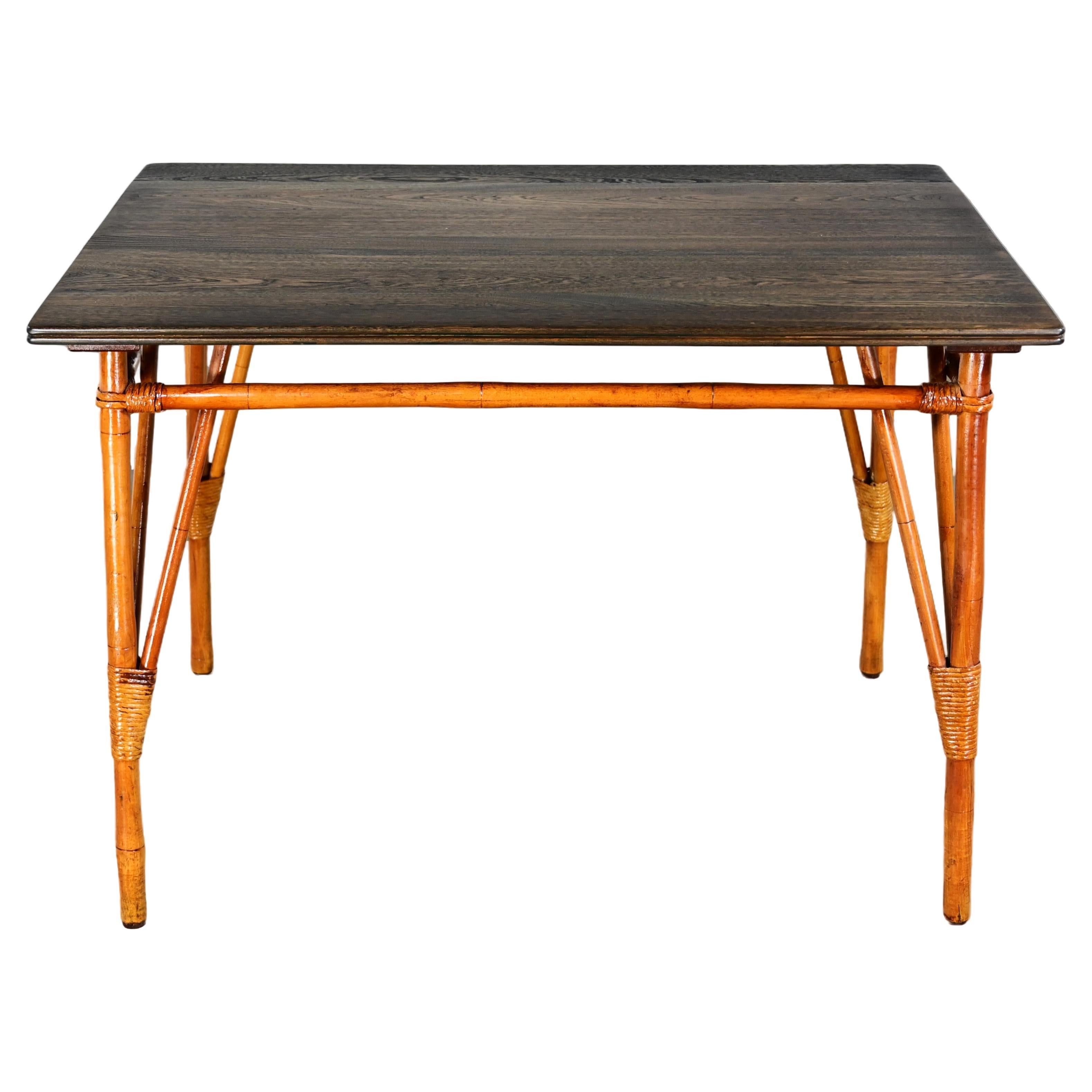 Table de salle à manger en rotin de style îlot du milieu du 20e siècle avec plateau en bois dur teinté ébène en vente