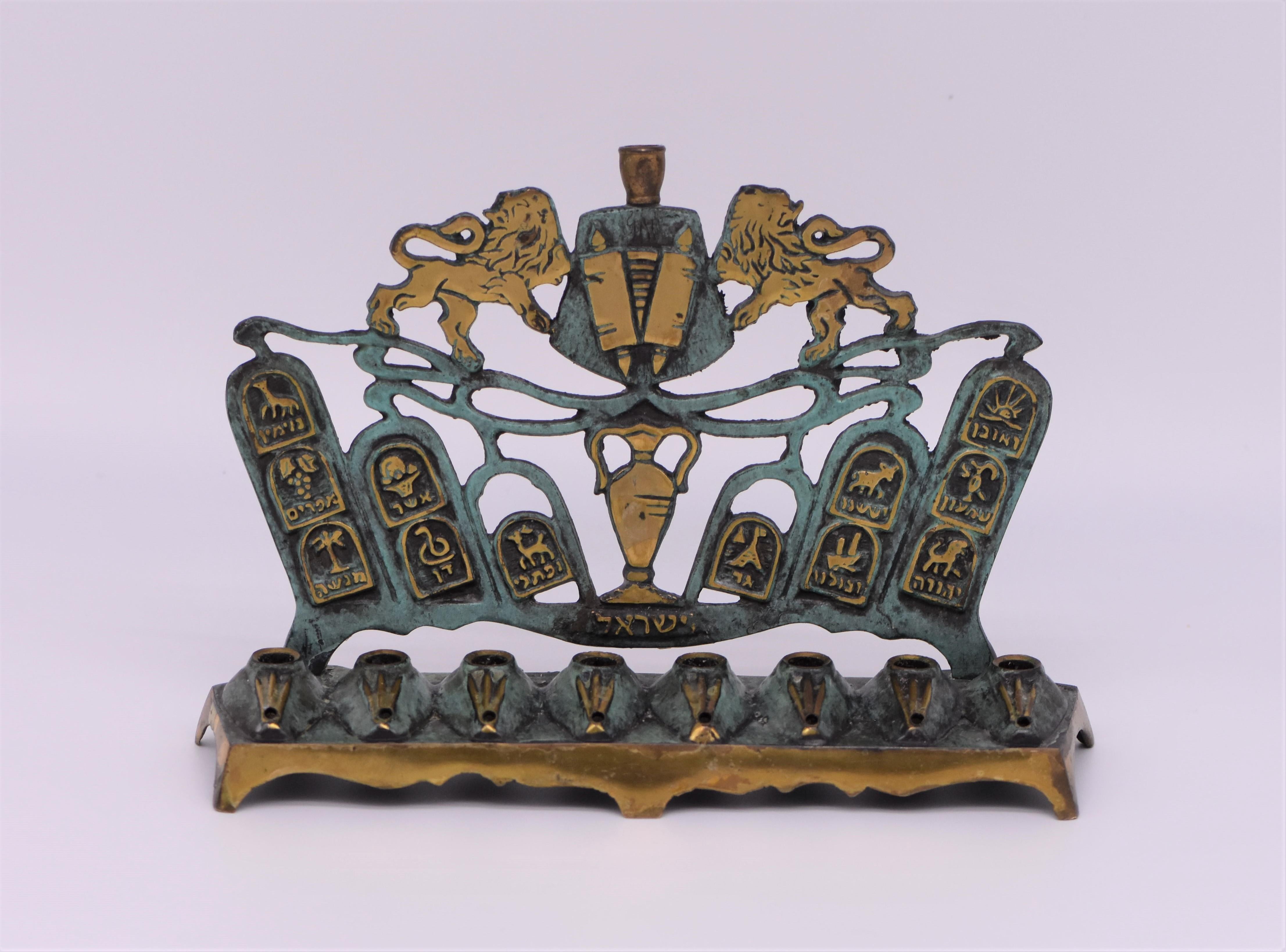 Cast brass Hanukkah lamp, Israel, circa 1950. 
Covered with beautiful original green patina, bearing in gold Hebrew letters the word: 