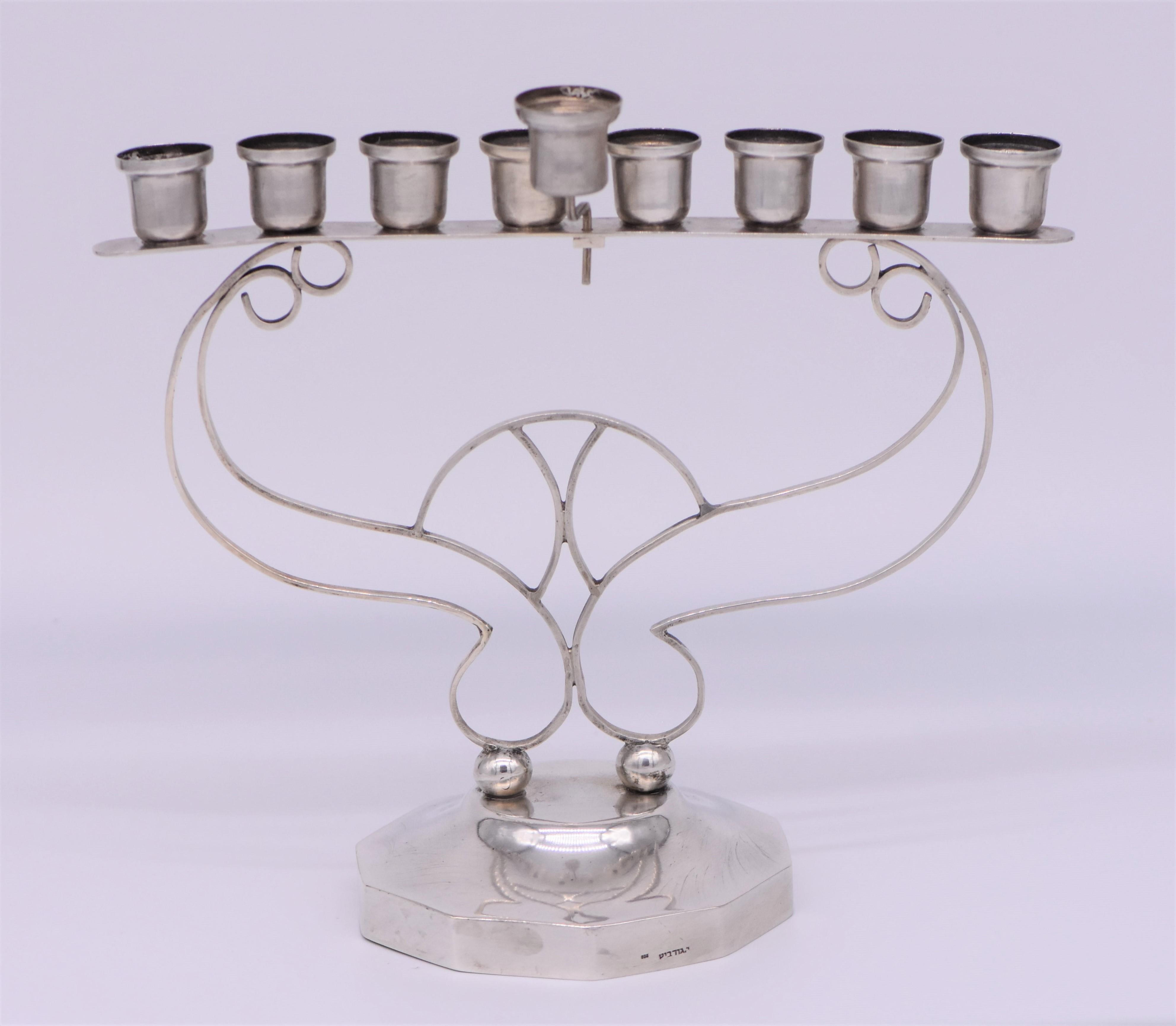 Handgefertigte Chanukka-Lampe aus Silber, Israel, ca. 1940er Jahre.
Schöne Arts & Crafts Chanukka-Lampe von I. Gurevitz. mit großer Hand Silberarbeit mit massiven Silberdrähten in der Mitte, verbunden mit acht Kerzenhalter und mit dem