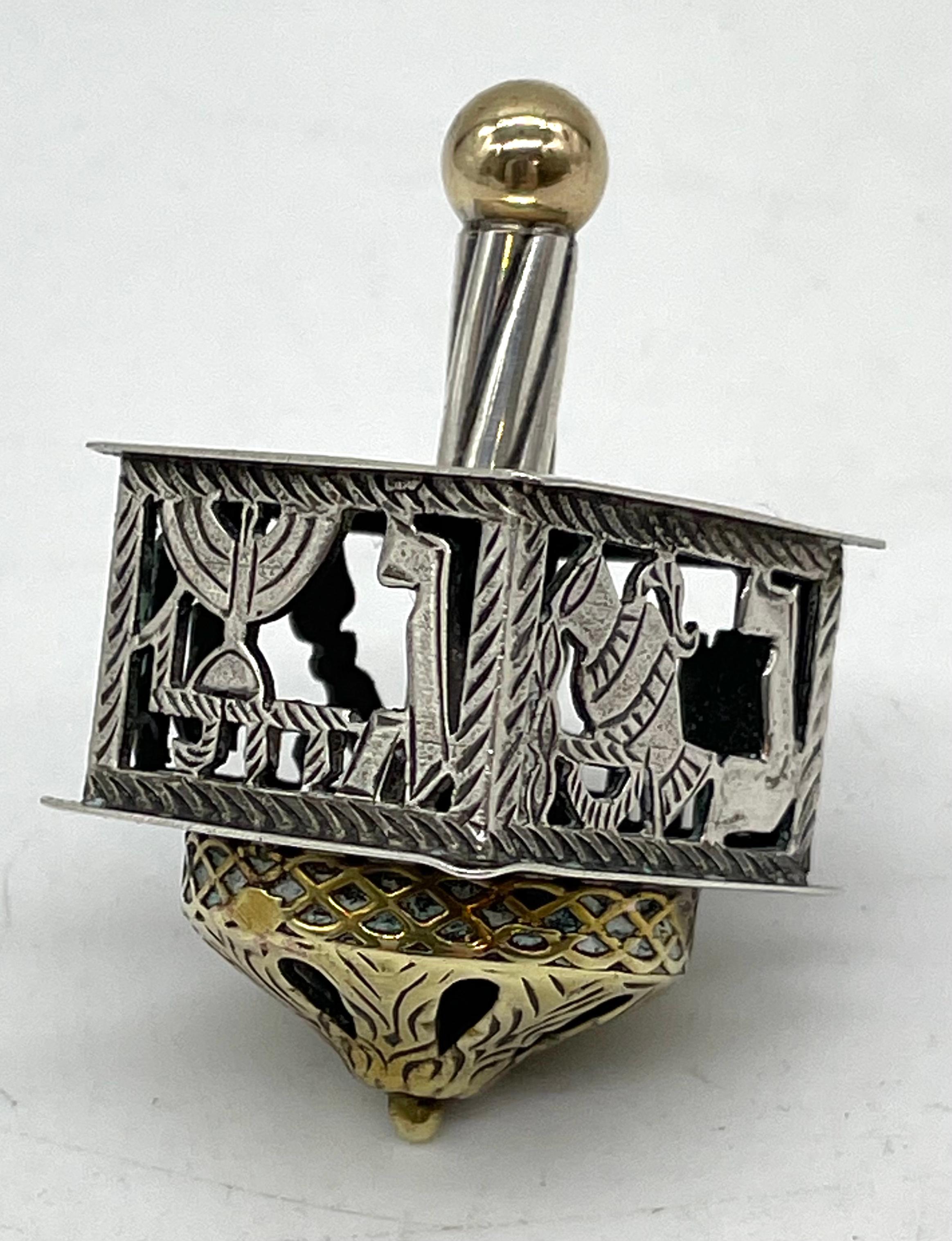 Handmade sterling silver Hanukkah dreidel, Jerusalem, Israel, circa 1955. Stamped with Israeli silver hallmarks with gilded top and bottom. The four letters nun, heh, gimel, shin on each flank represent Nes gadol haya sham, meaning 