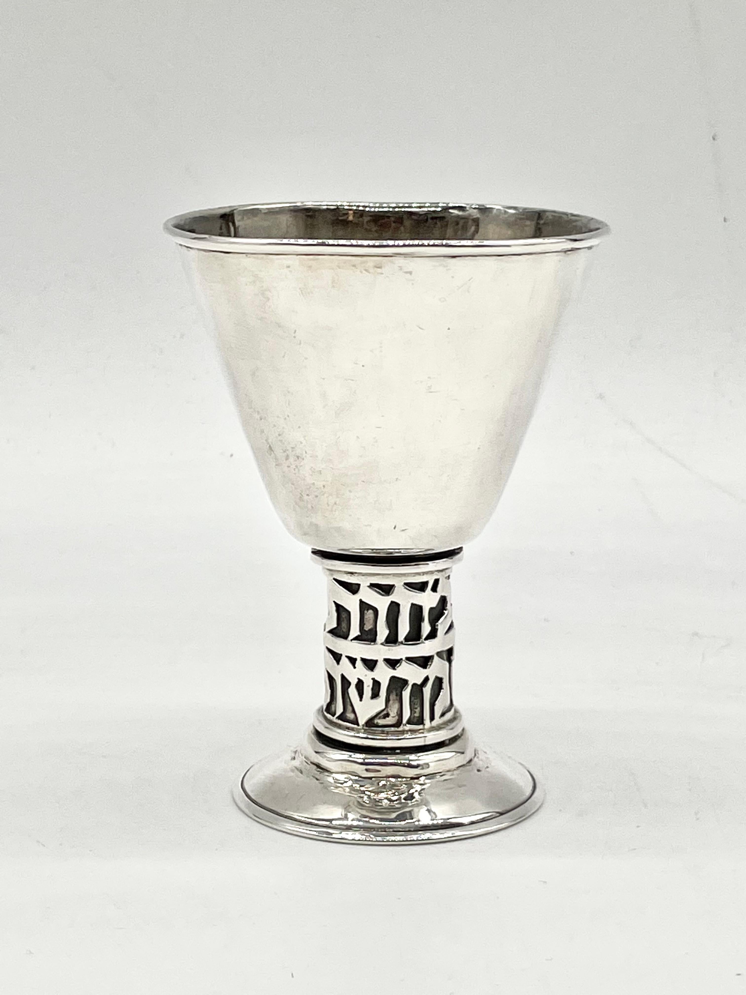 Modern sterling silver Kiddush goblet designed by Hans Ettlinger. 
Hand hammered in Jerusalem, Israel, circa 1950.
Stem embossed with Hebrew inscription: “Because you chose us & made us holy “ Marked 