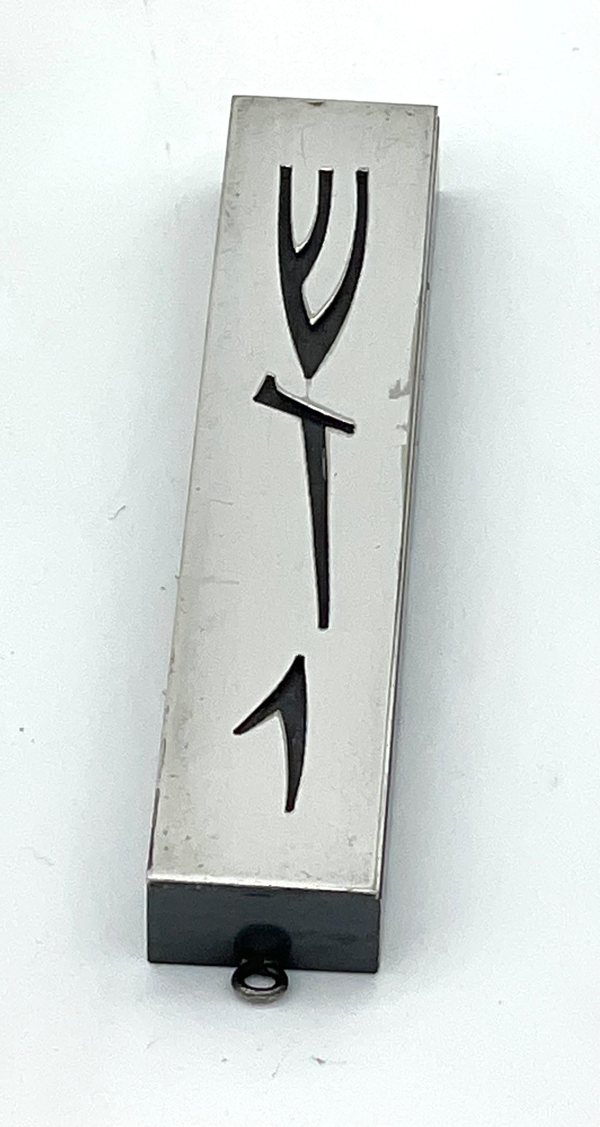 Handmade in Jerusalem, this Israeli silver-plated mezuzah is distinguished by its strikingly modern aesthetic. Brutalist design of Hebrew letters from top to bottom read, “Shaddai” used for one of the names of G-d. The letters displayed shows a