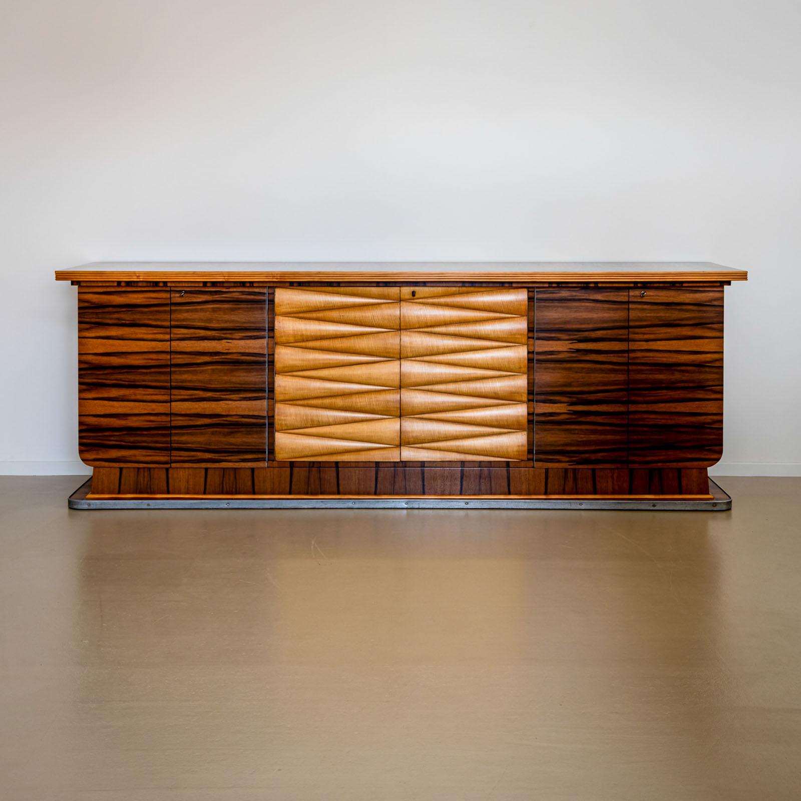 This impressive Italian Art Deco sideboard from the 1940s features six doors and a central section distinguished by a wavy front, accented in satinwood. The remainder of the sideboard is beautifully veneered in walnut. Inside, the sideboard is