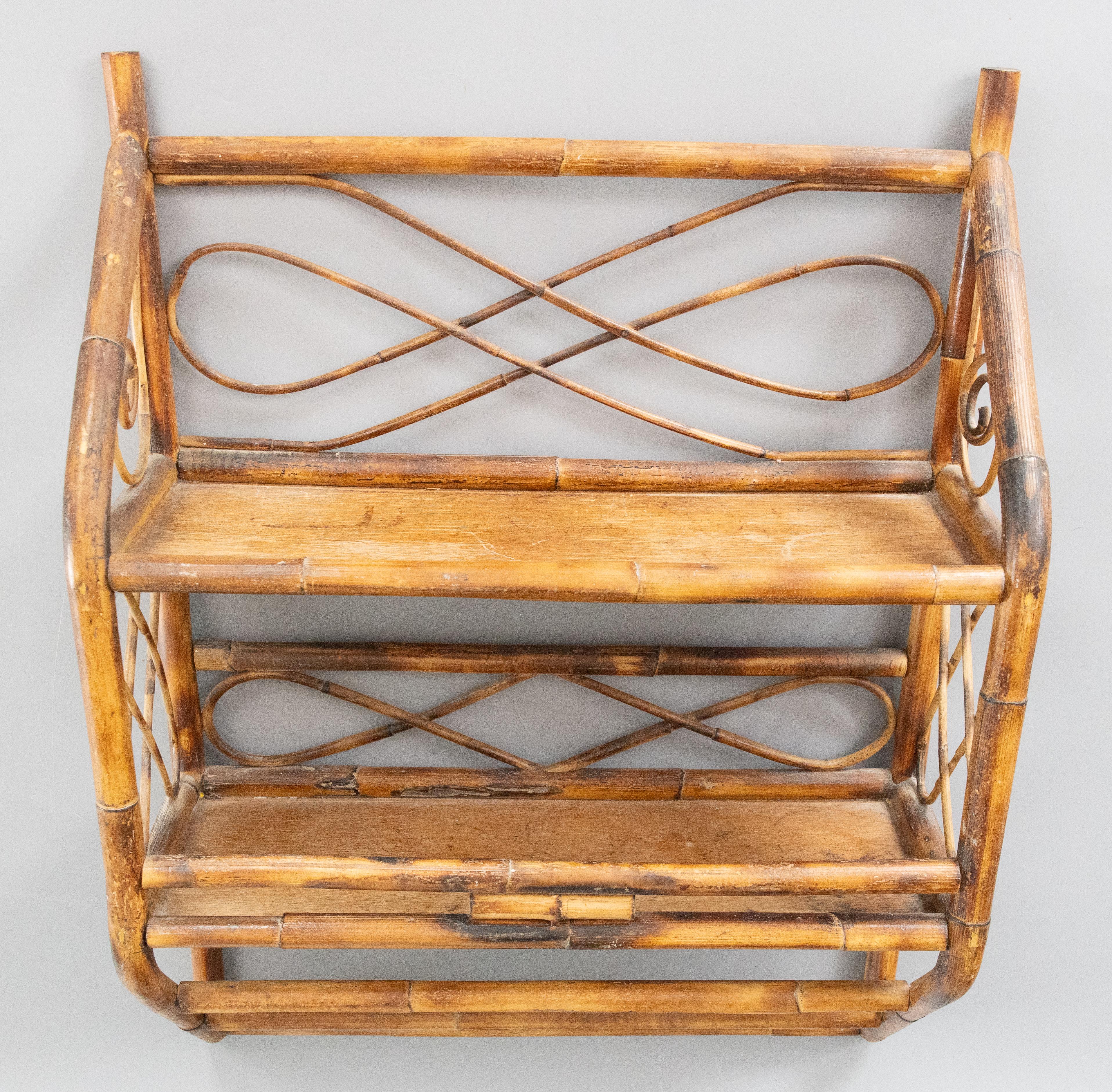 Elegante estantería de pared italiana de mediados de siglo, de ratán y bambú, de dos niveles, hacia 1960. Precioso diseño en espiral de ratán en los laterales con el acabado original. Perfecto para exponer objetos de colección. 

Dimensiones
18ʺAN ×