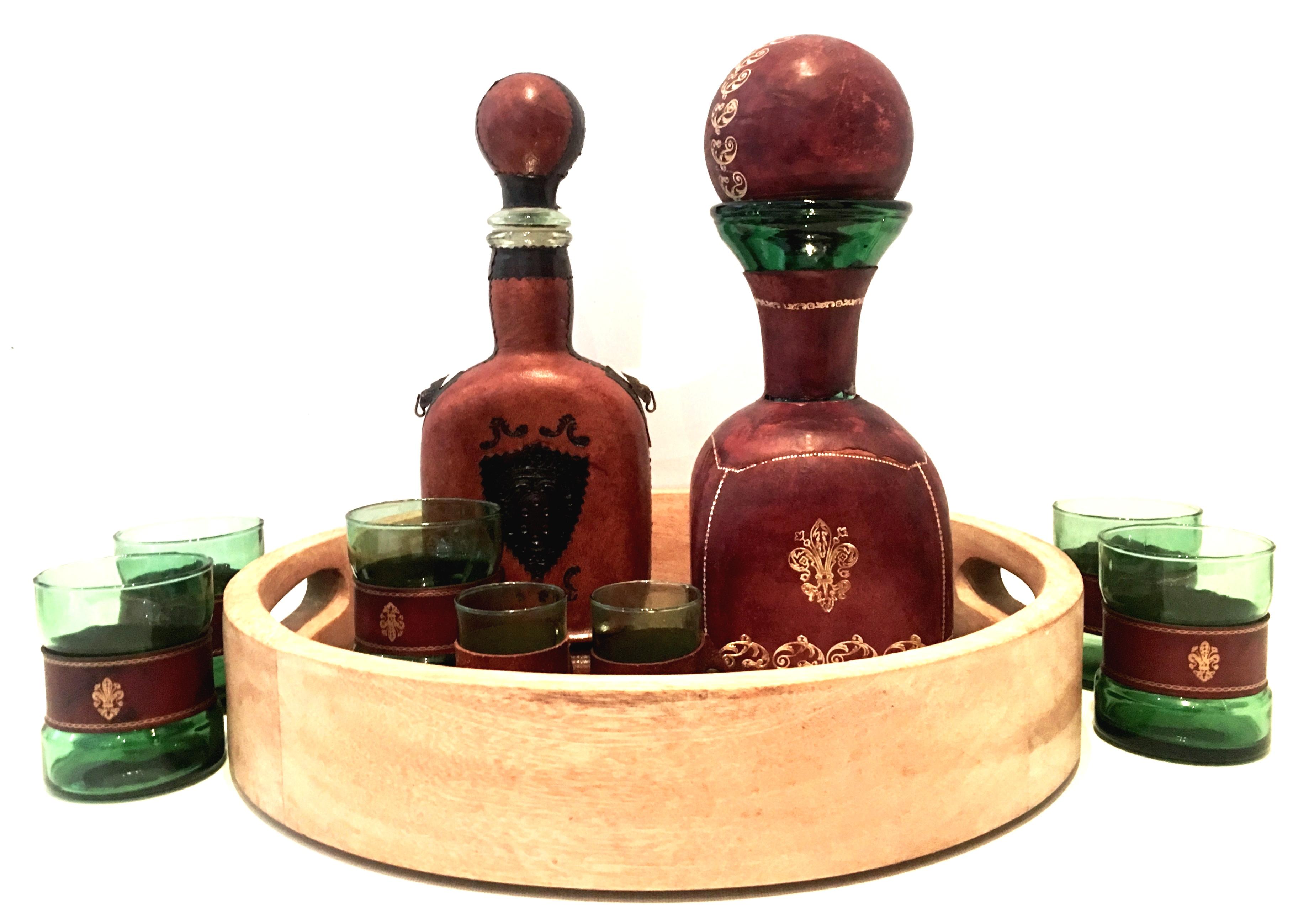 Mid-20th century Italian blown glass and leather drinks set of 10 pieces. Set features emerald green blown glass, Italian soft and durable leather wrapped decanters and glasses with a new wood and mirrored cut out handle tray. Set includes two