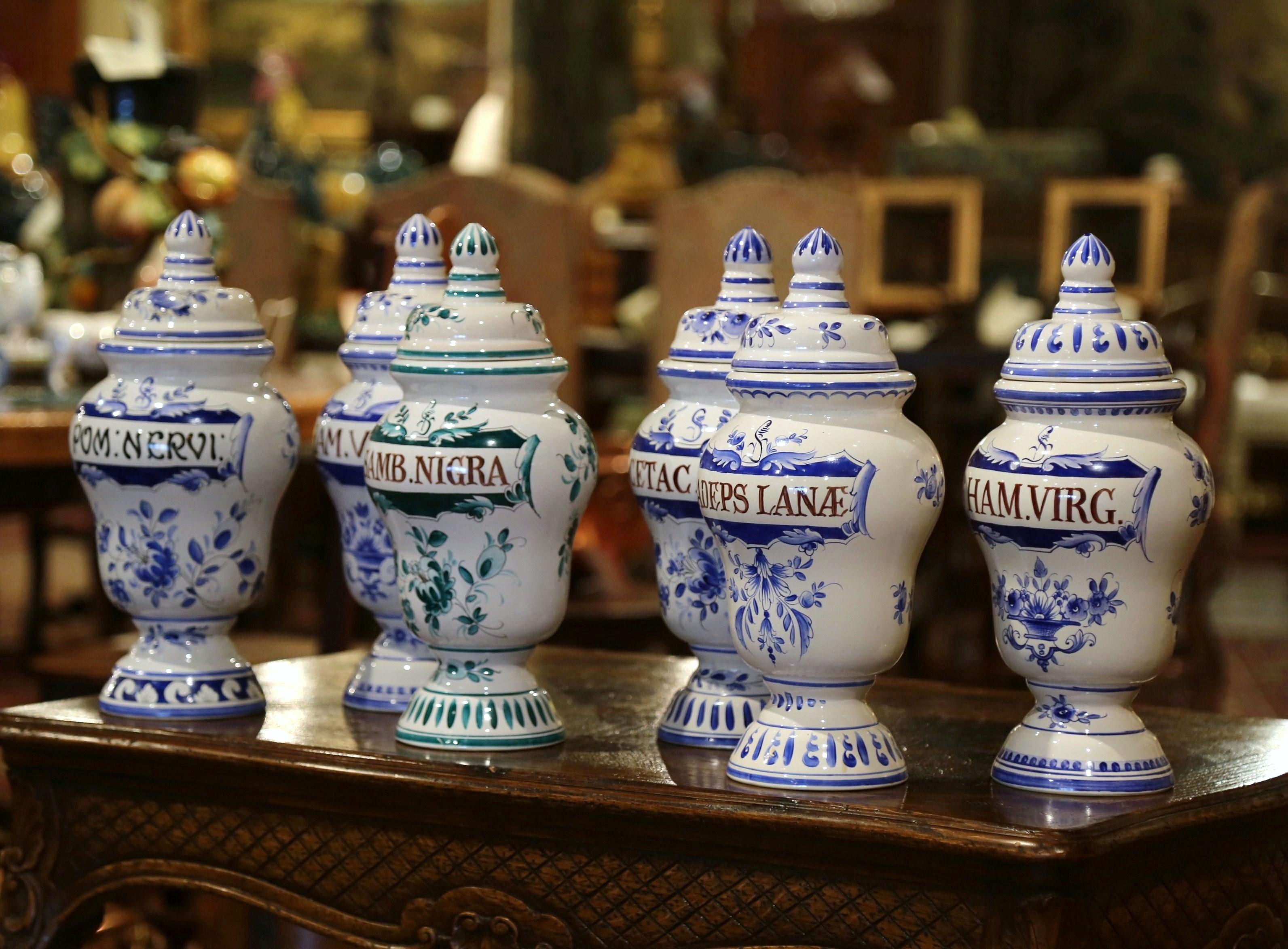 Decorate your bathroom or your kitchen cabinets with this colorful set of apothecary jars; created in Italy, circa 1970, each faience jar has a dome shaped top and features hand painted floral motifs in the manner of Delft in the blue and white