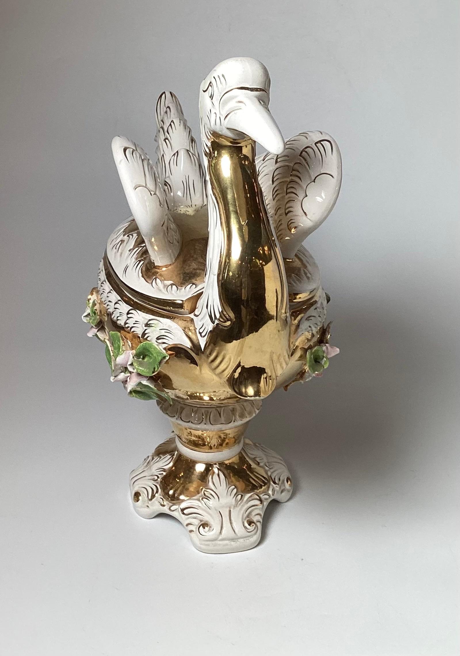An unusual stork motif Italian hand gilt and decorated porcelain tureen.  In the manner of Capodimonte, with gold decorated body with hand colored applied flowers all over.  20 inches tall, 22 inches wide, 9 inches deep. 