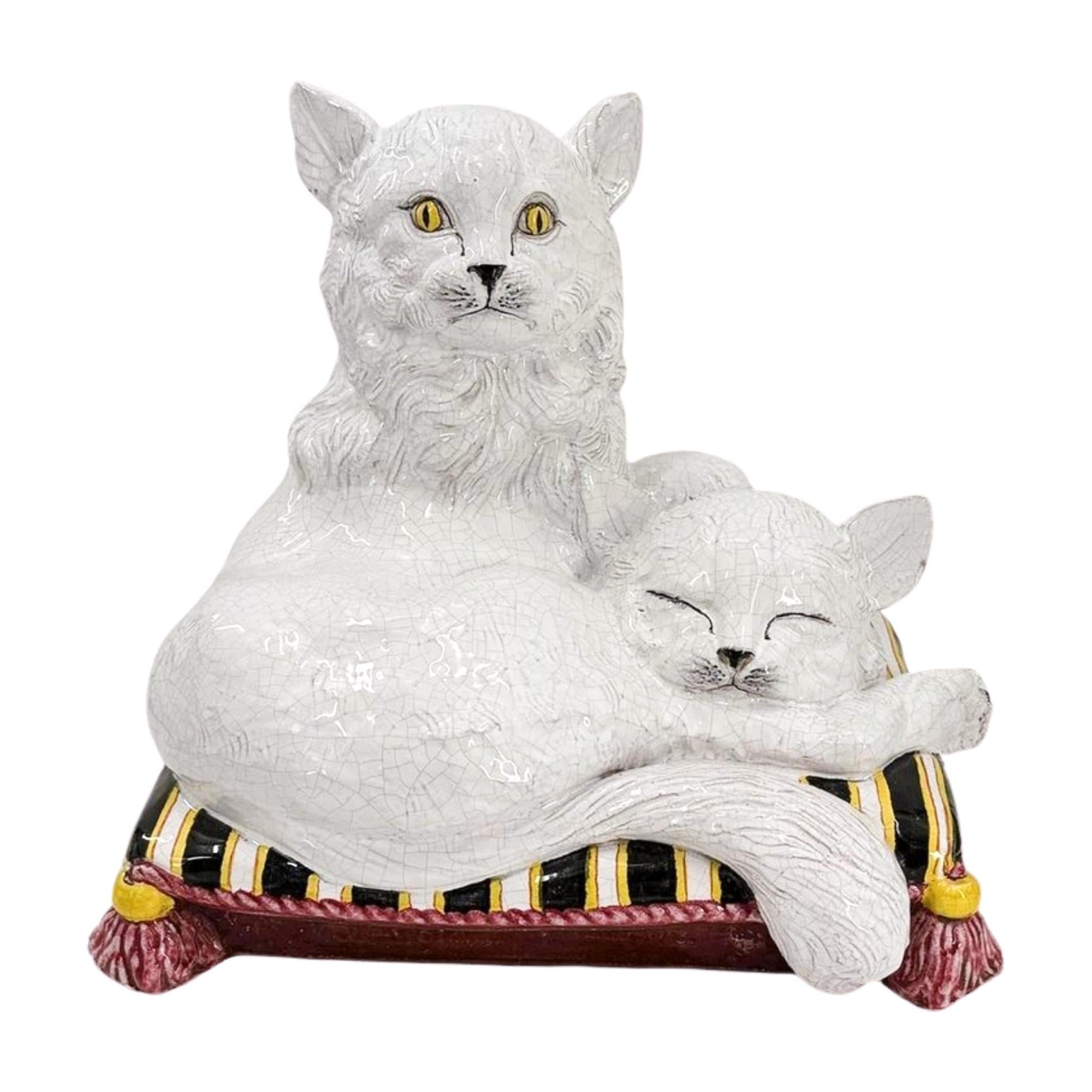 Firmata dal ceramista italiano Ceccarelli, questa scultura vintage cattura il fascino affettuoso di due gatti che riposano insieme su un cuscino con nappe. Il gatto più grande a pelo lungo guarda verso l'esterno con occhi gialli e luminosi, mentre