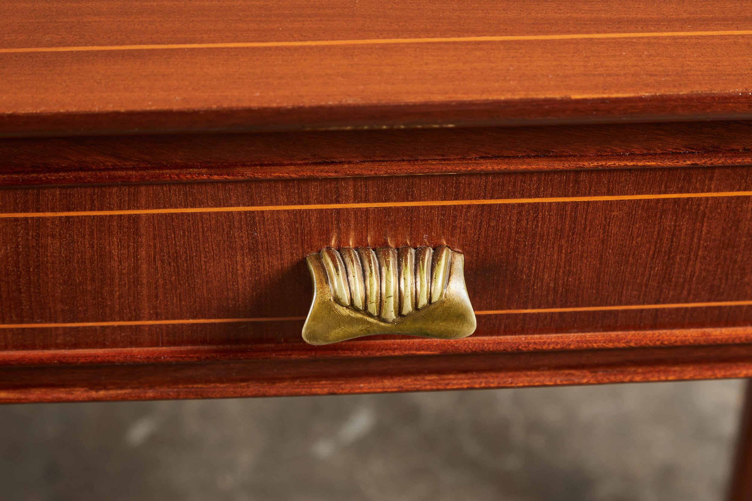 A 1940s Italian console with three drawers in Paolo Buffa style. Slim legs and delicate inlays make this piece both elegant and understated. Gold-toned hardware and gently curved front. Minor blemish on top, minimized greatly with new restoration.