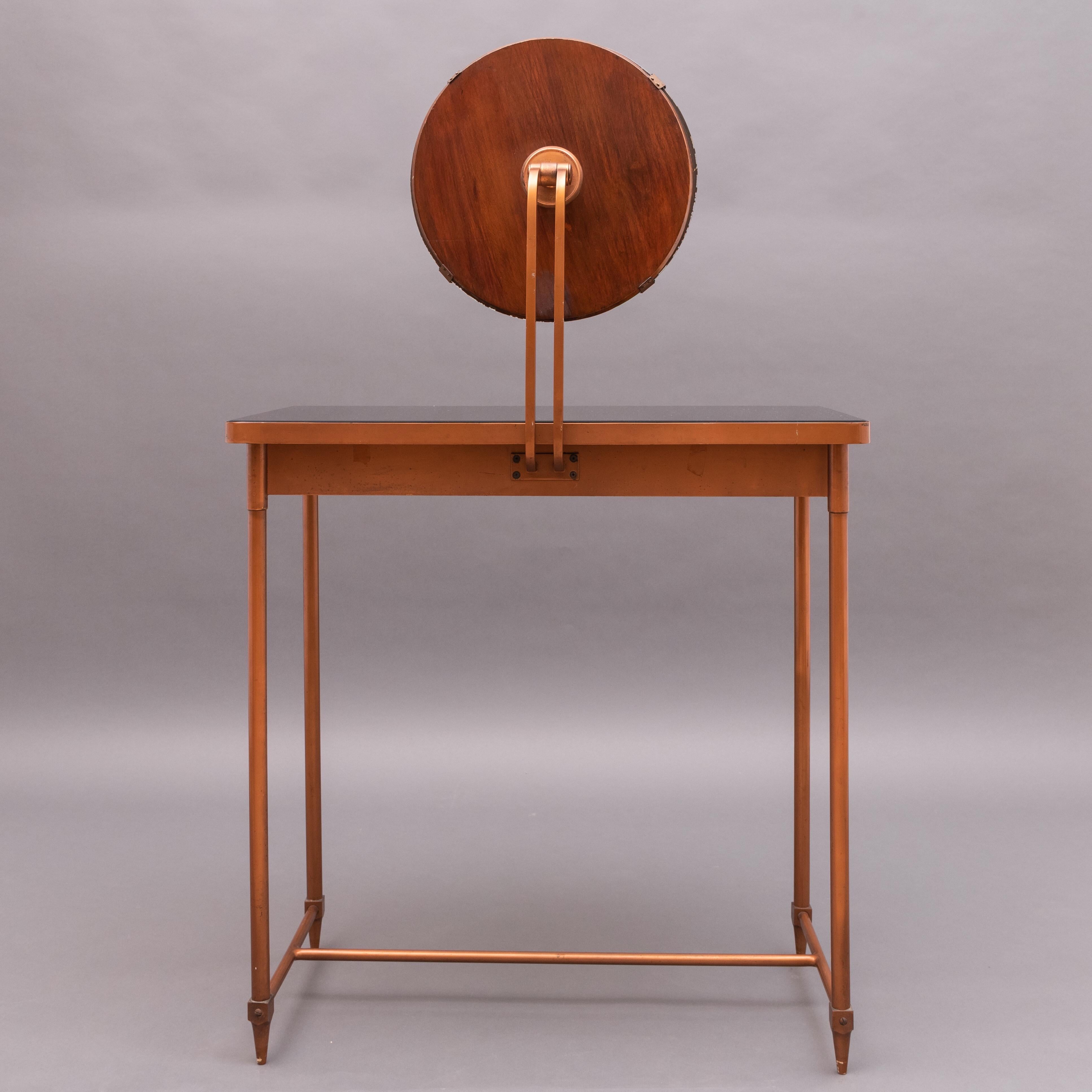 Mid-Century copper vanity table with its original black glass top. One-drawer.
Round mirror with a wooden base. Brass details.