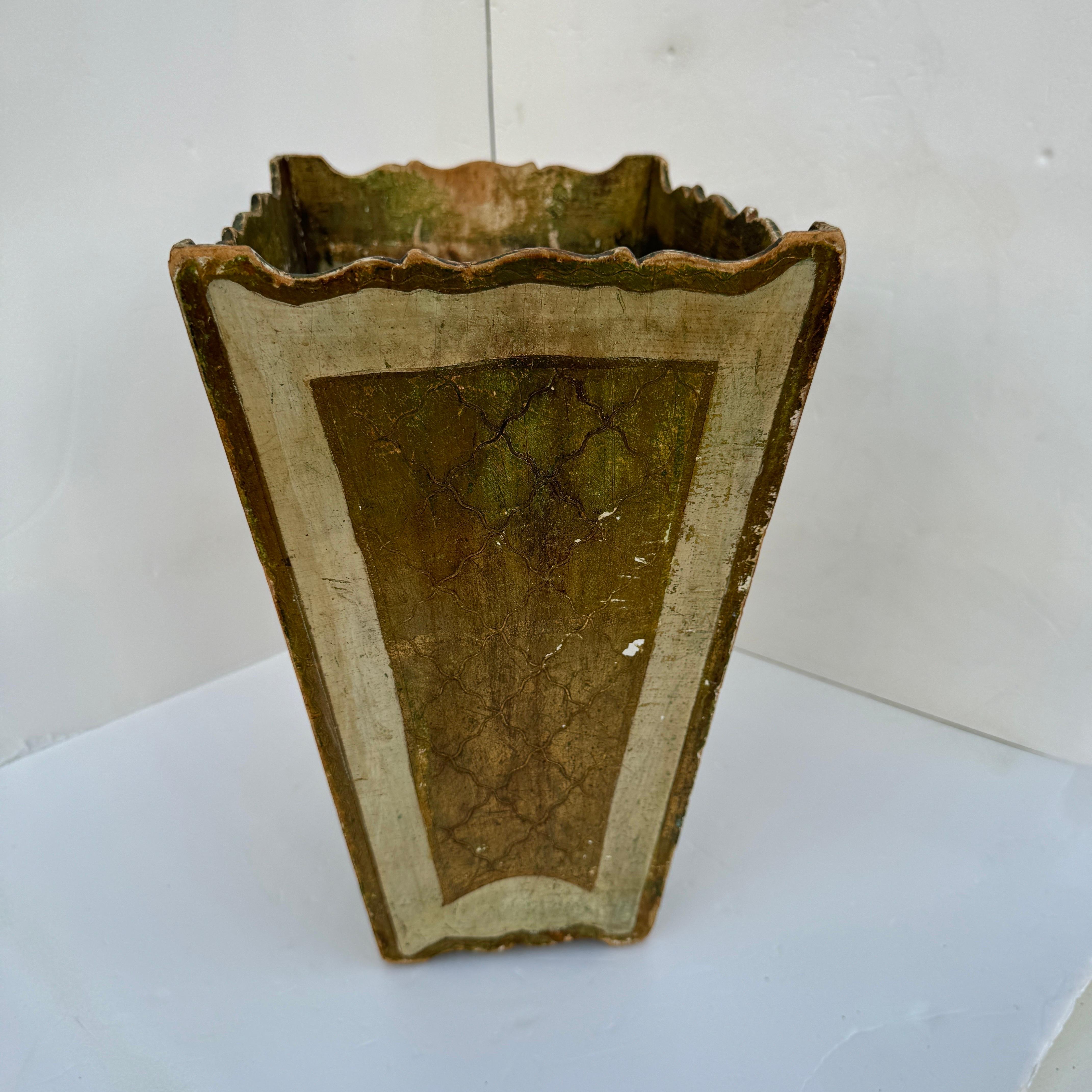 This exquisite 1950s vintage Florentine wastebasket, crafted in Italy, showcases the timeless elegance of mid-century design. Made from carved giltwood, it features an ornate floral and scrollwork motif, beautifully highlighted in gleaming gold leaf