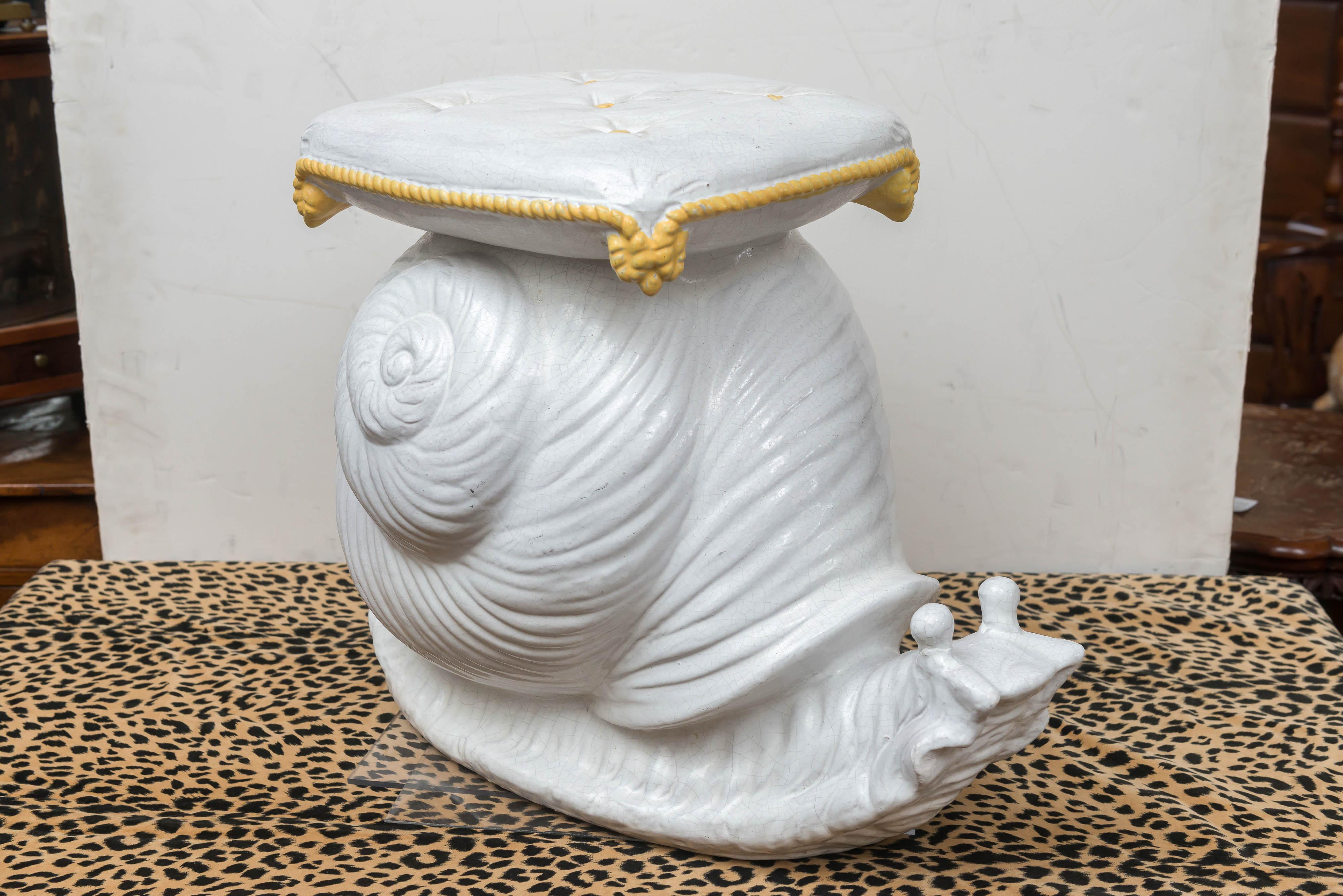 Mid-20th century Italian garden stool of a snail, circa 1960.
A large snail shell with a cushion form seat on top. The snail head out with both stalks up as in motion. White glaze with the cushion trimmed in a green cord over a Heavy cast terra