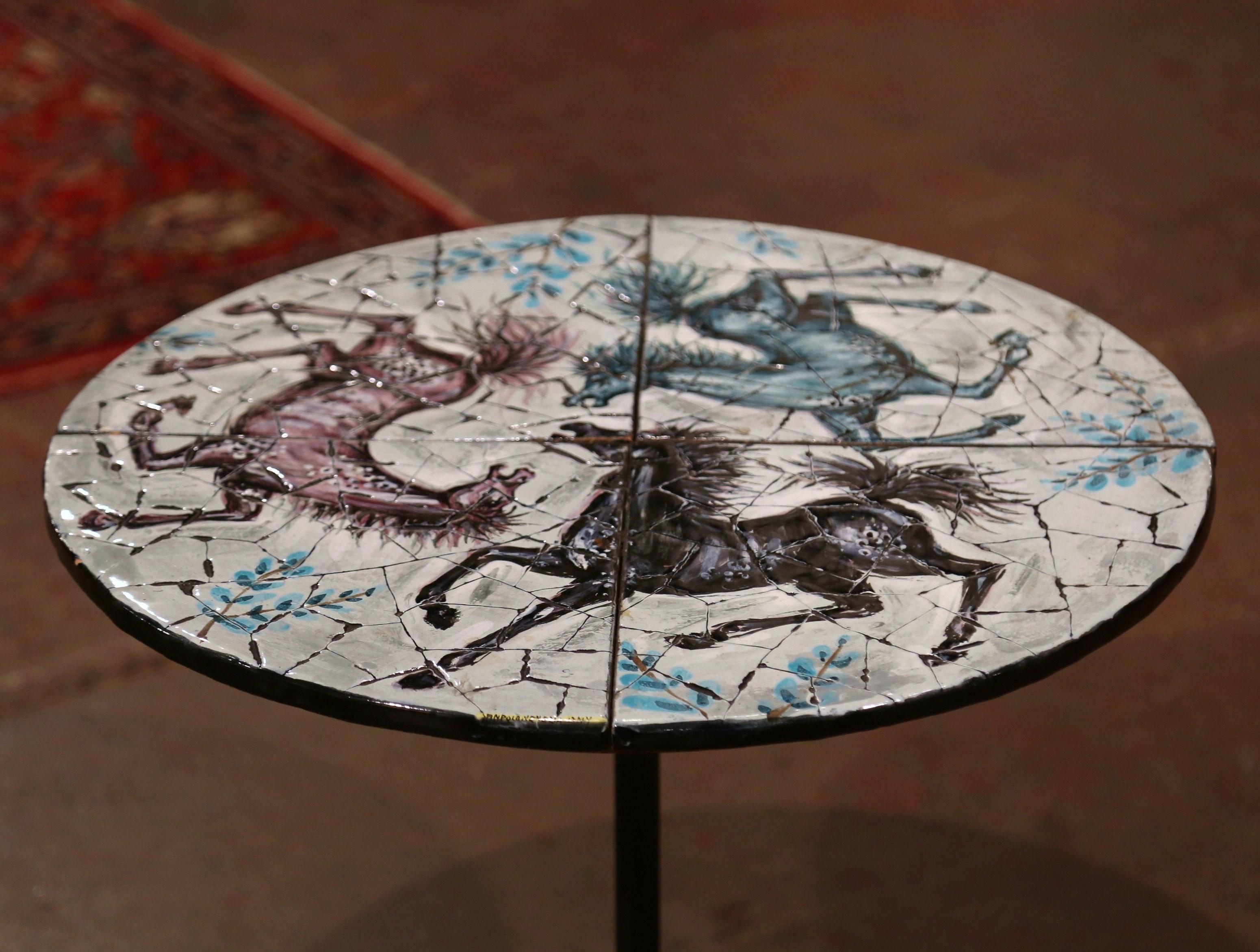 Decorate a patio or a garden with this elegant bistrot table, forged in Italy, circa 1960, the side table sits on a iron base with three scrolled feet. The colorful mosaic marble top features three carousel horses in the blue and white palette. The