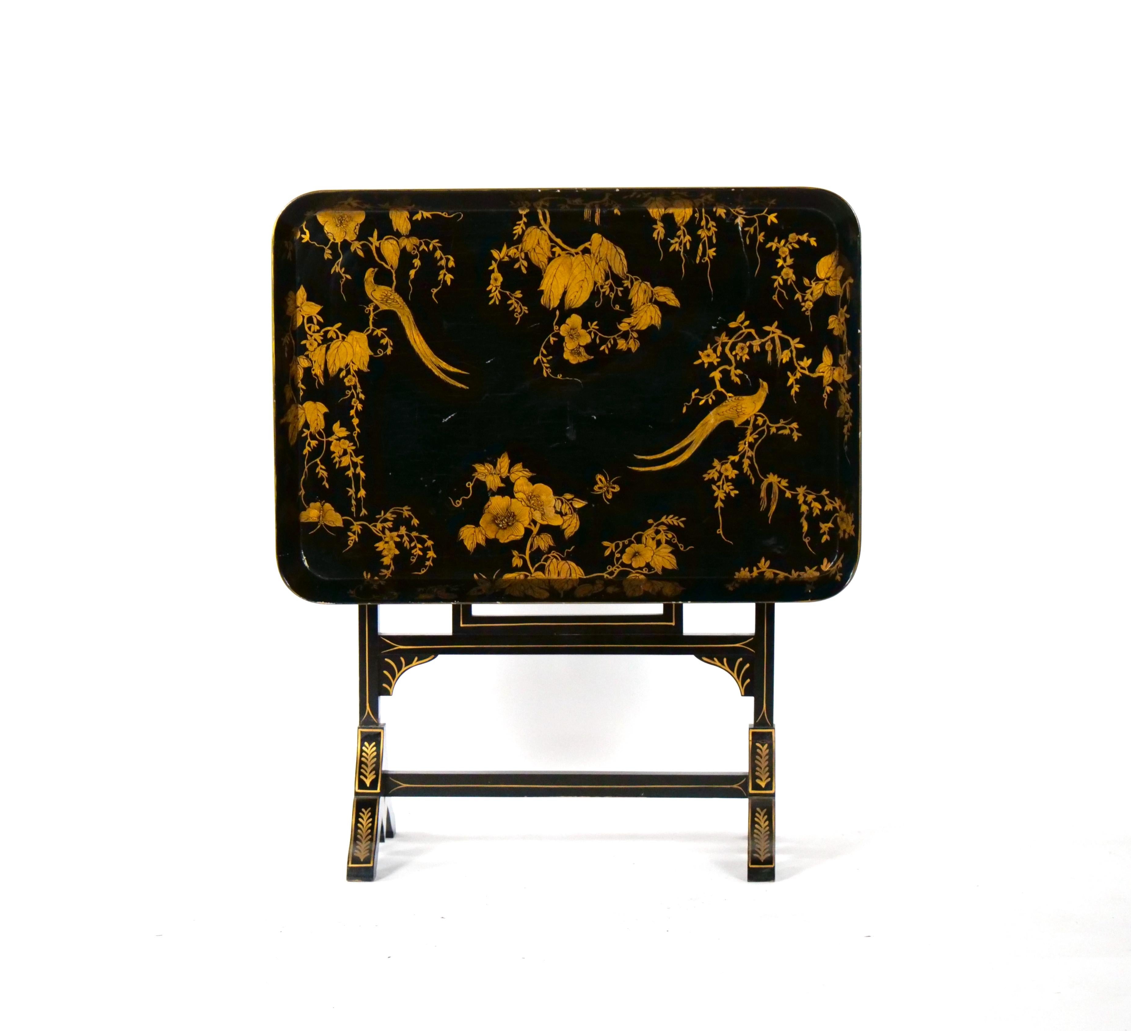Beautiful Mid-20th Century Italian hand painted and gilt decorated floral and birds chinoiserie tray table. The tray is made with black lacquered wood, beautifully executed and handsomely hand painted with floral , birds , foliate and gild all
