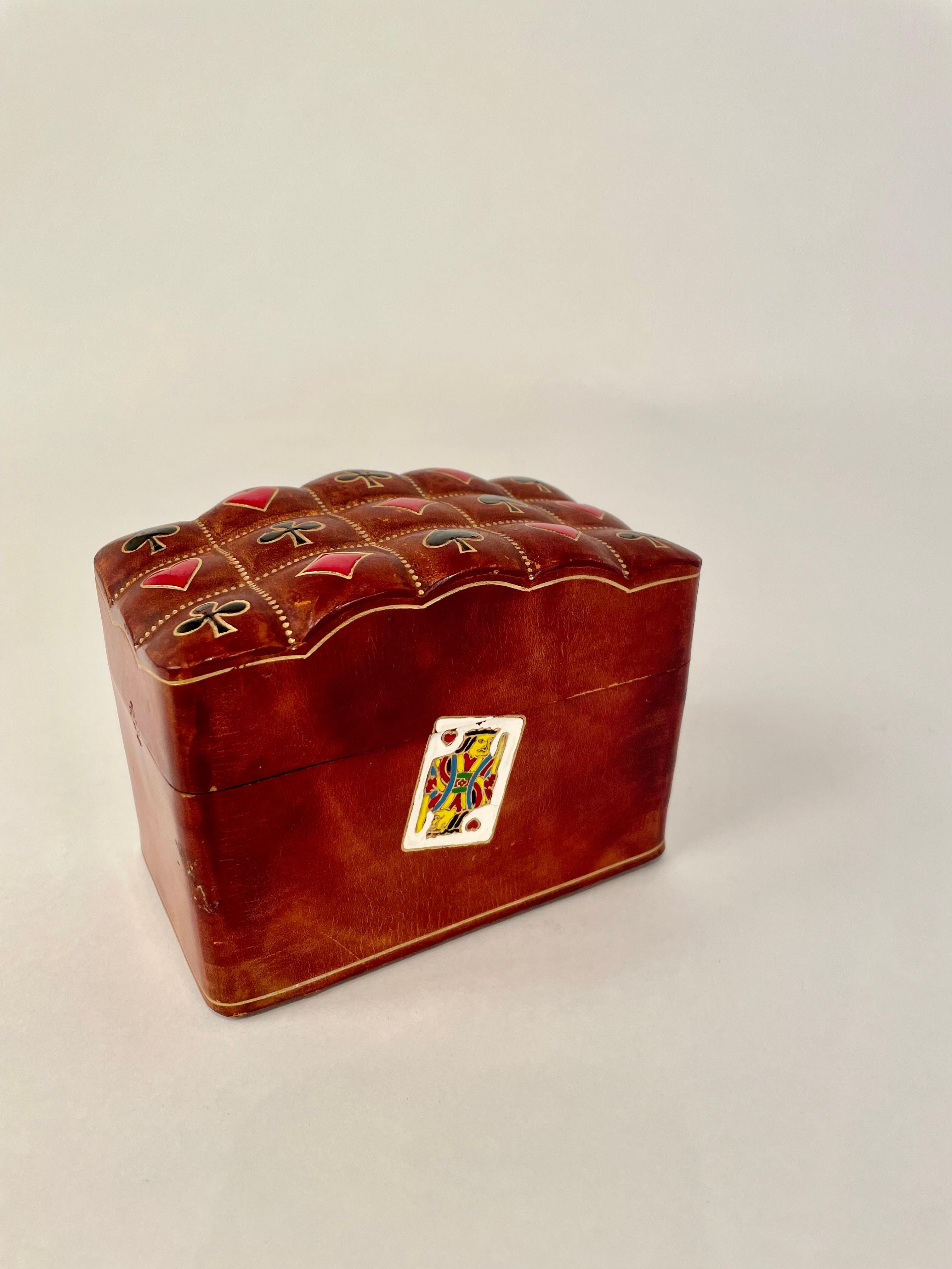Wonderful Italian handcrafted tooled leather playing card case with painted enamel-like decoration of cards on the sides and symbols for all the suites, clubs, diamonds, spades and hearts on the cushion top. Beautifully made and clearly loved, a