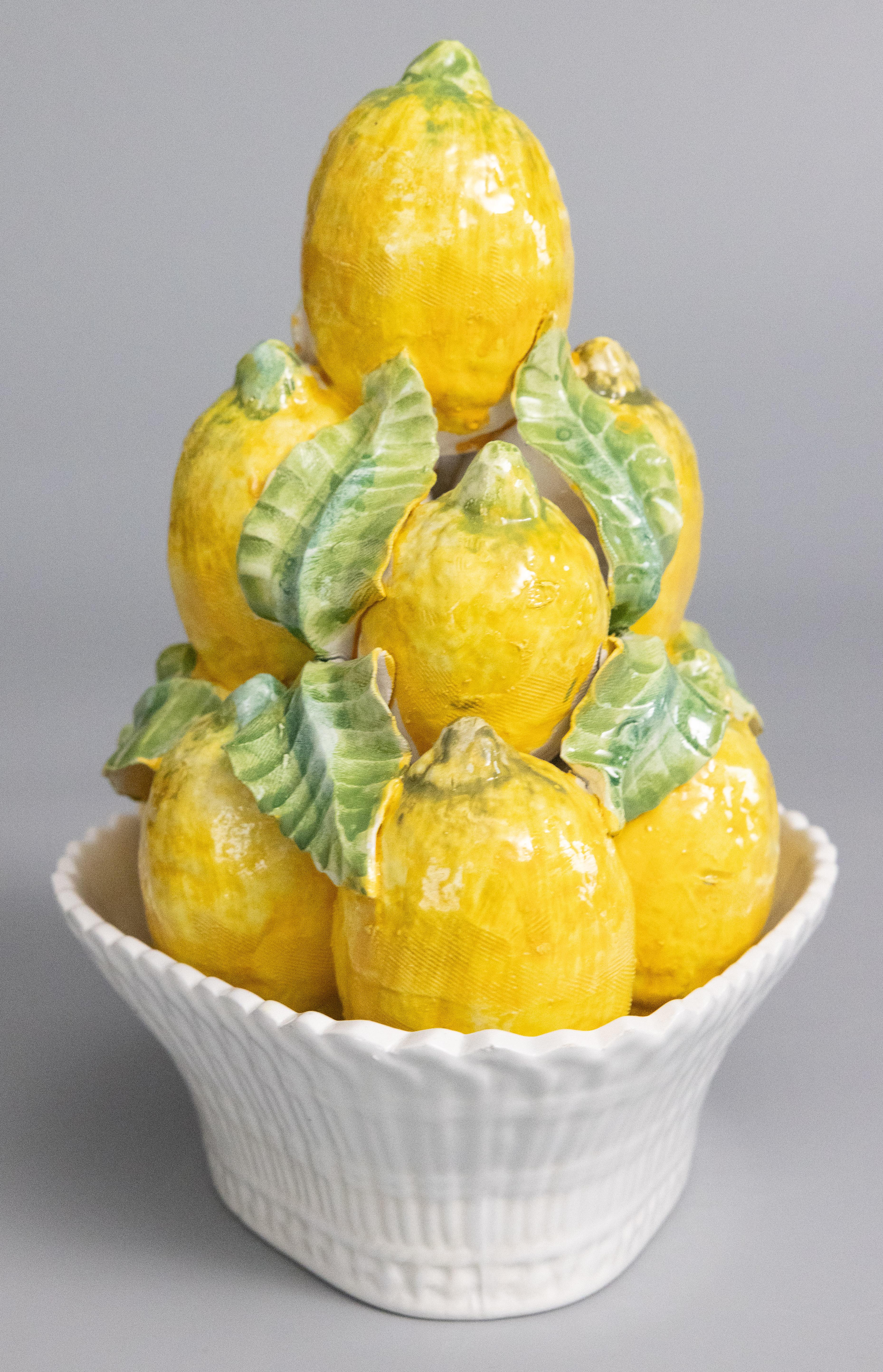 A lovely Mid-Century Italian majolica basket of lemons topiary centerpiece. Freshen up your kitchen or breakfast room with this charming hand painted arrangement of lemons accented by vibrant green leaves in a white latticework