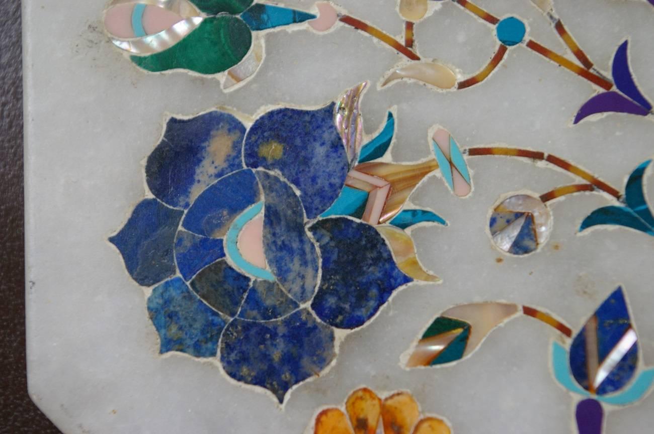 This is a beautiful piece of artwork called Pietra Dura, it is a white marble tile inlaid with various kind of colorful marble, semi precious stones and mother-of-pearl. This is made in Italy, circa 1950s-1960s.

The measurements are:
Depth 0.6