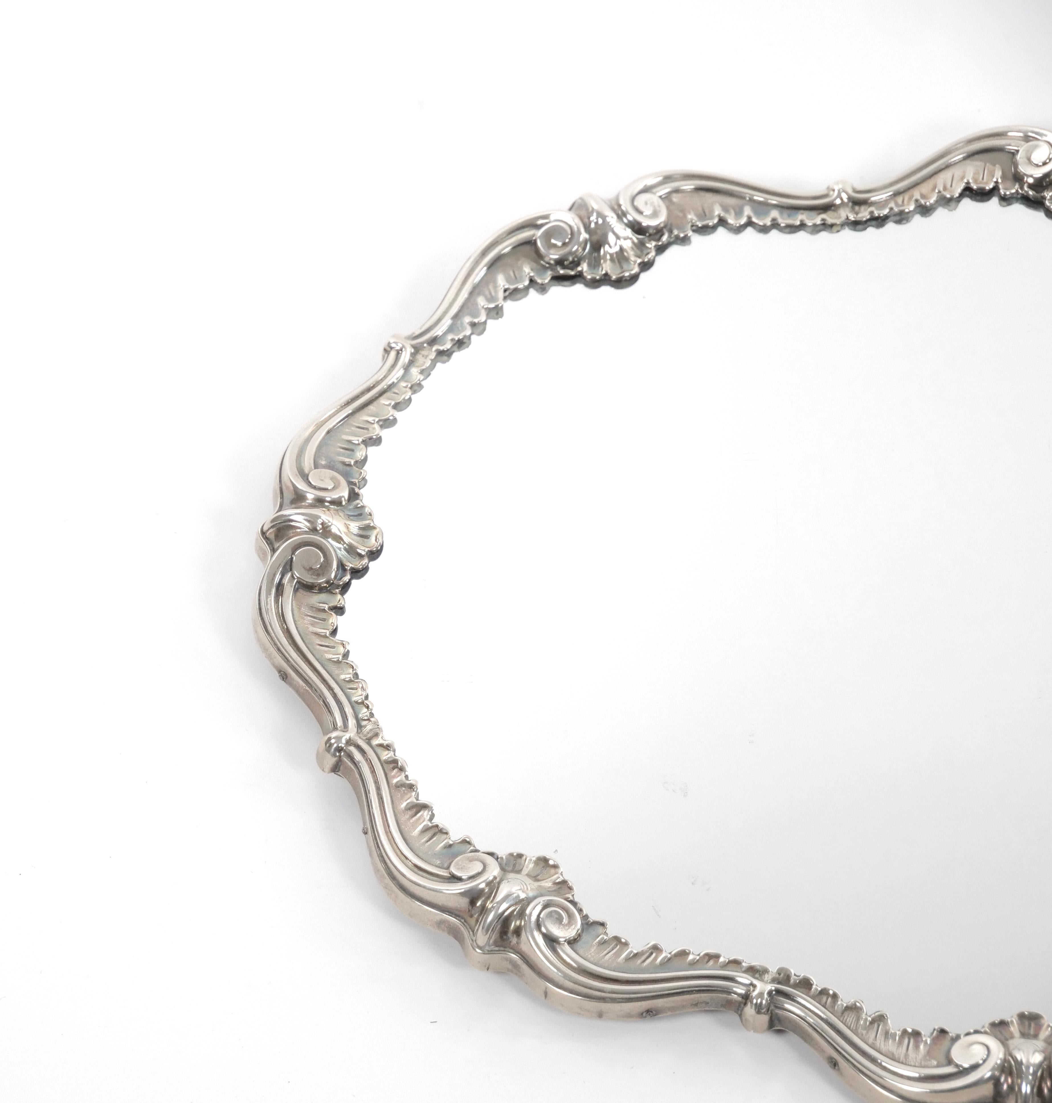 
Experience the epitome of Italian craftsmanship and sophistication with our exquisite Italian silver plate mirrored plateau. This captivating piece combines a striking scrolling shape with meticulously engraved border decorations, resulting in a