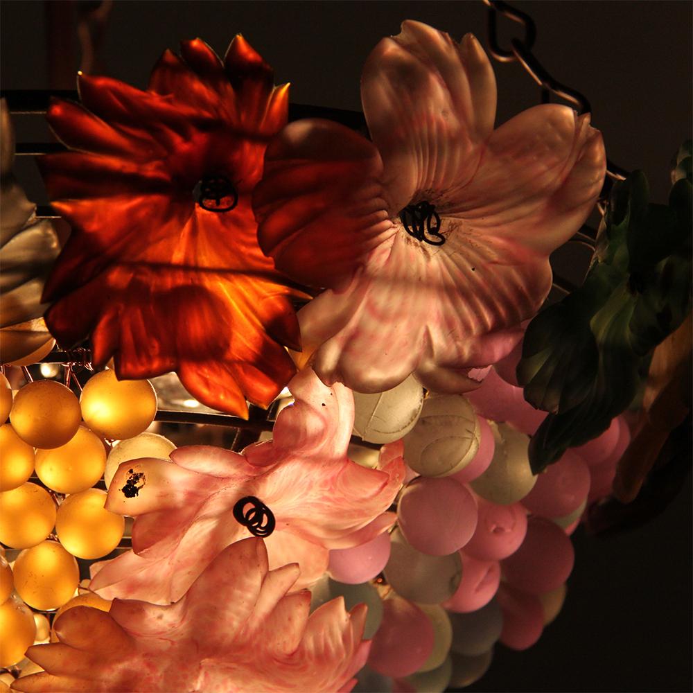 An Italian Murano chandelier in the manner of ‘Cesare Toso’. Of basket form, the chandeliere features handmade flowers and grapes in a variety of colors. It is newly professionally rewired to North American standards.
The chandelier has a warm