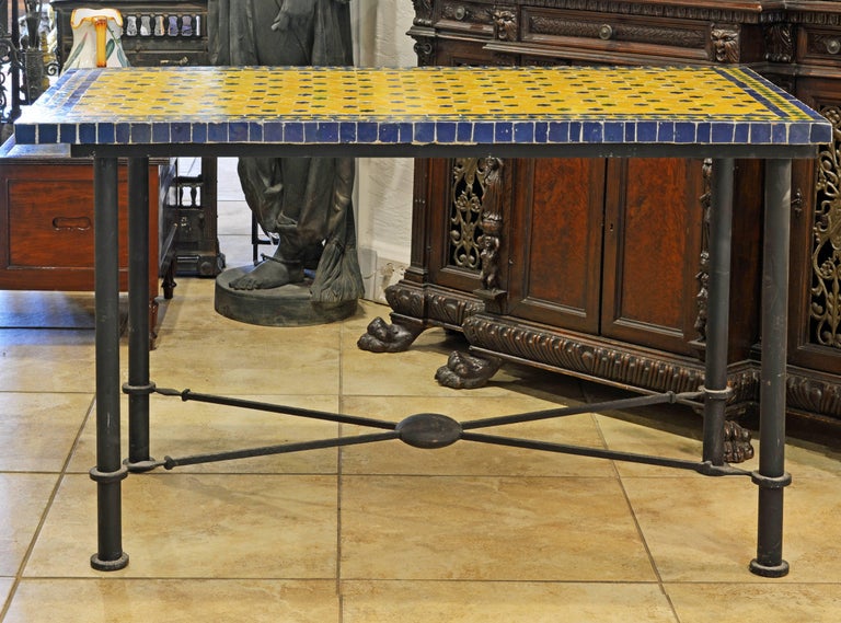The yellow, blue and green colors of the Venetian style mosaic make this table very attractive both for indoor and outdoor use. Its iron frame is designed in the classical Pompeian style with round legs spearheaded stretchers united by a circular