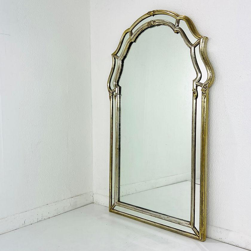An Italian Regency style parclose wall mirror, unbranded. Mirrored glass in a solid wood frame painted gold. Features arched top with strips of mirrors surrounding on outer edges. Made in Italy, in the mid 20th Century.   

Measures: 26w 1.5d