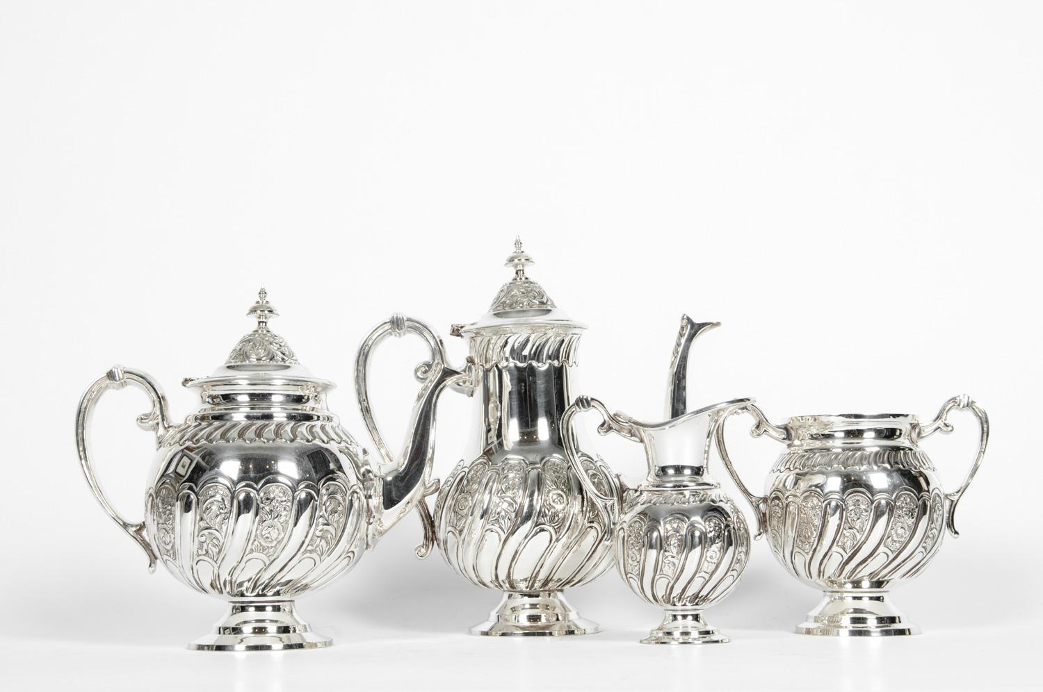 Un raffinato servizio da tè e caffè in silverplate italiano della metà del XX secolo, composto da quattro pezzi di ottima fattura. Il set comprende una caffettiera, una teiera e una lattiera, tutte finemente decorate con delicati disegni repoussé e