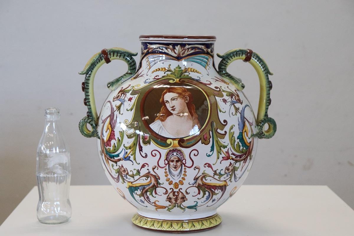 Nous vous présentons cet étonnant grand vase, fabriqué à Faenza, en Italie, datant des années 1950. Le vase est fabriqué en céramique émaillée polychrome. La décoration classique peinte de chaque côté de ce vase ne manquera pas d'attirer