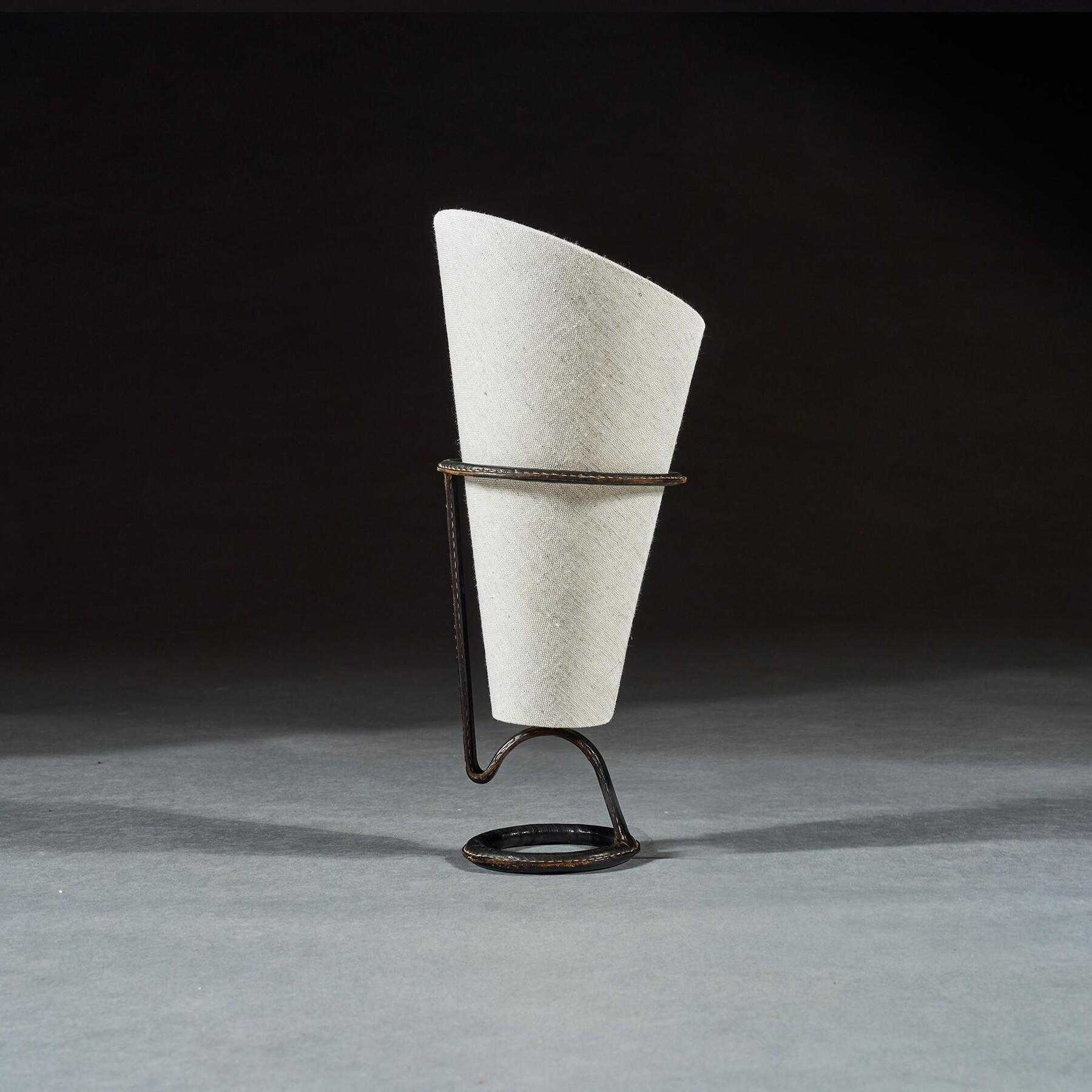 A Remarkable Torch or Cone-Shaped Table Lamp, Attributed to Jacques Adnet, 



French Circa 1955



This striking design, utilising a folded torch or cone-shaped linen shade is firmly attributed to Jacques Adnet. The lamp base makes use of some of