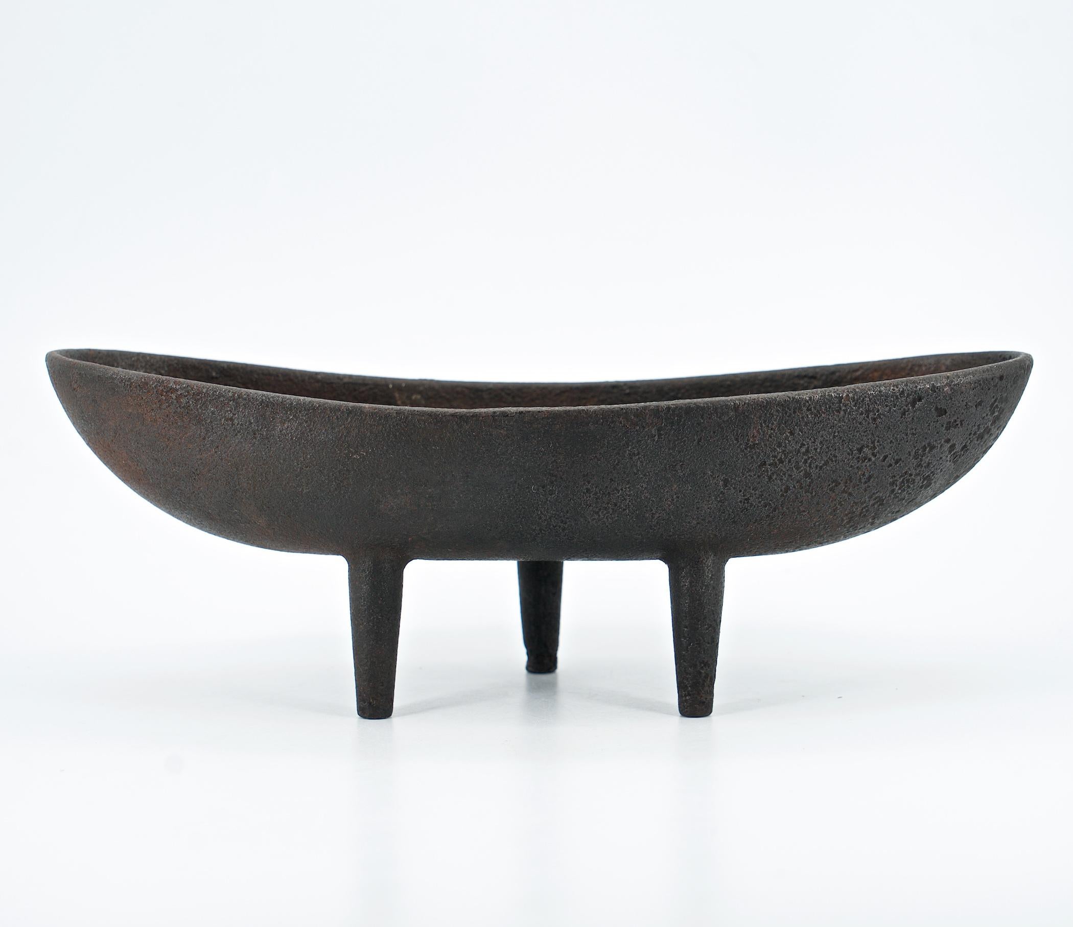 Very early and more primitive production of this now famous elongated footed vessel design on three pronged feet. This one is unmarked, and over 10 5/8 inches long.

The design and time period is similar and parallel to Isamu Noguchi's famous cast