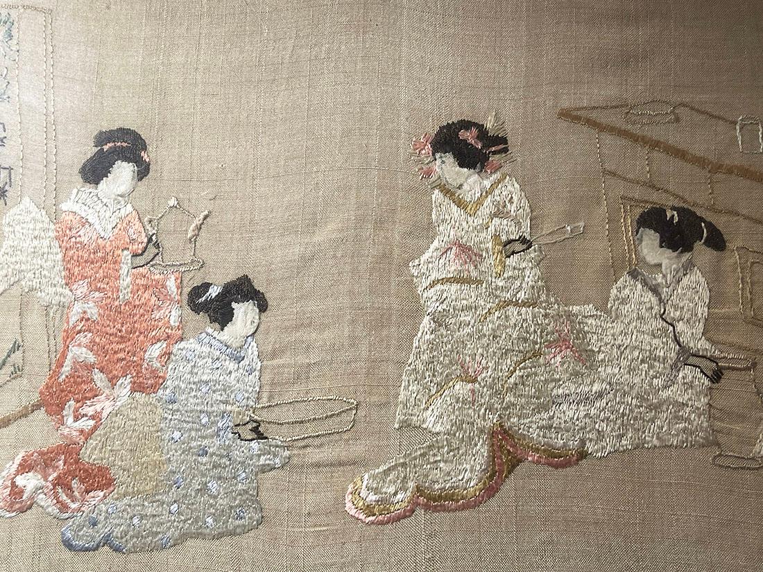 Mid-20th Century Japanese silk embroidered framed painting

A silk embroidered painting and is framed behind glass with a scene of women in a room with a stork in the doorway in the background. The left winged women hold a bowl and a pot with a
