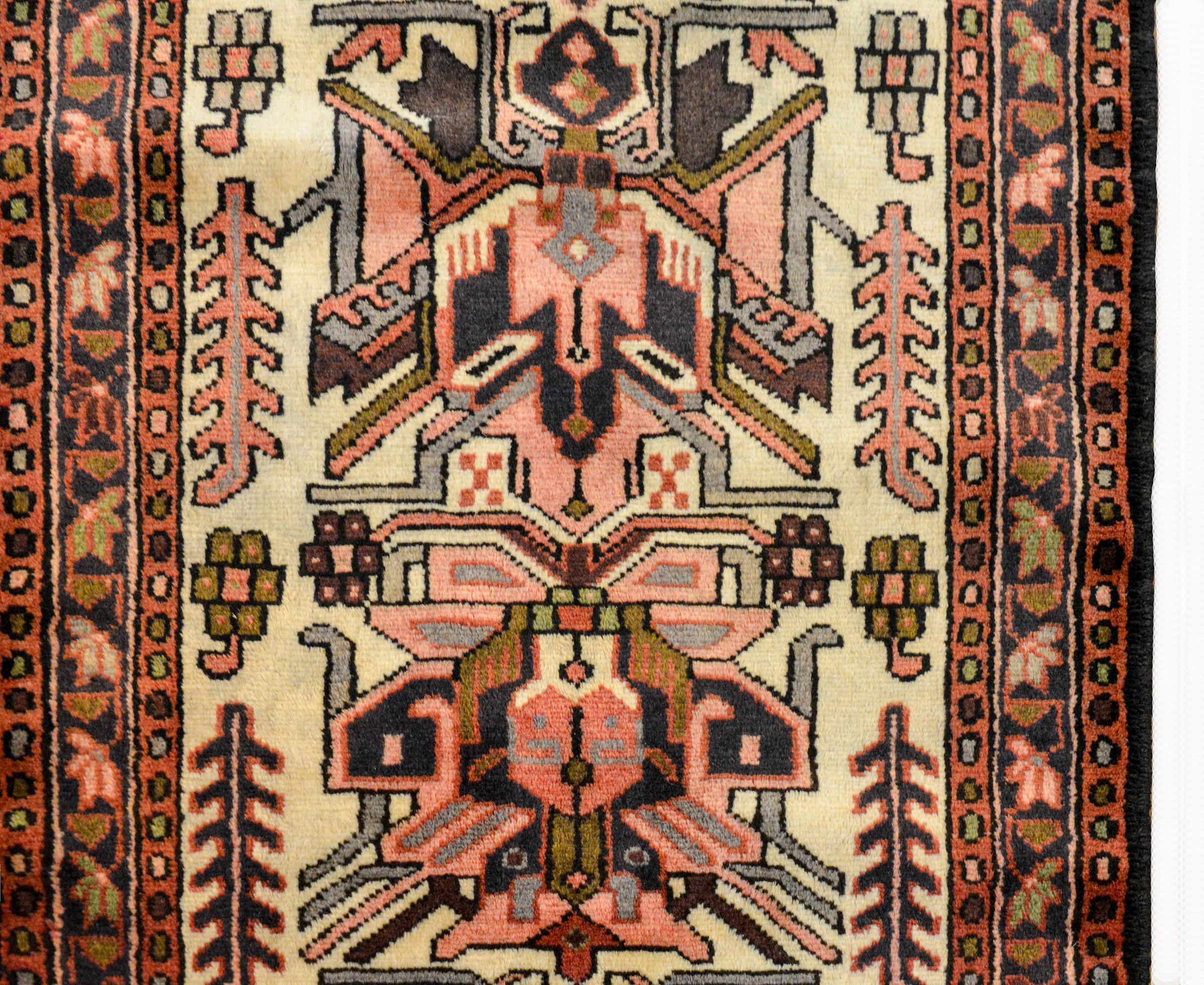 A wonderful mid-20th century Persian Karadja runner with multiple stylized floral medallions woven in black, pink, gold and gray amidst a field of more stylized flowers and leaves against a white background. The border is wonderful composed with