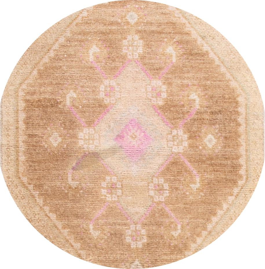 A beautiful Khotan-style rug from Pakistan with an ivory field, tan and pink accents in an all-over multi-medallion design. 

This hand knotted wool runner measures 2'4
