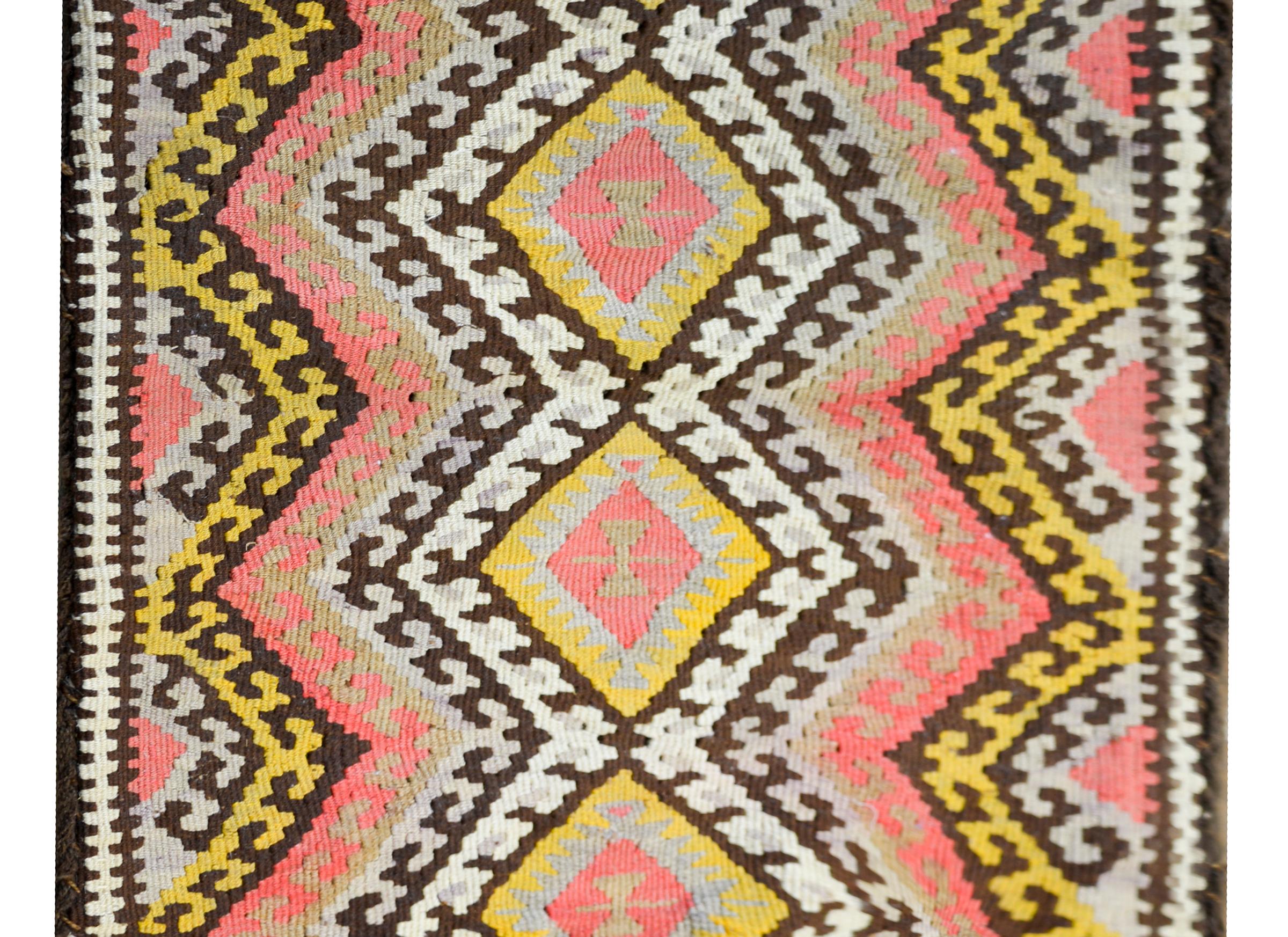A striking mid-20th century Persian kilim rug that once lived its life as a bag. The pattern contains four diamond medallions flanked by several bold geometric multi-colored zigzag stripes. Fill with pillow inserts and it becomes a large floor or