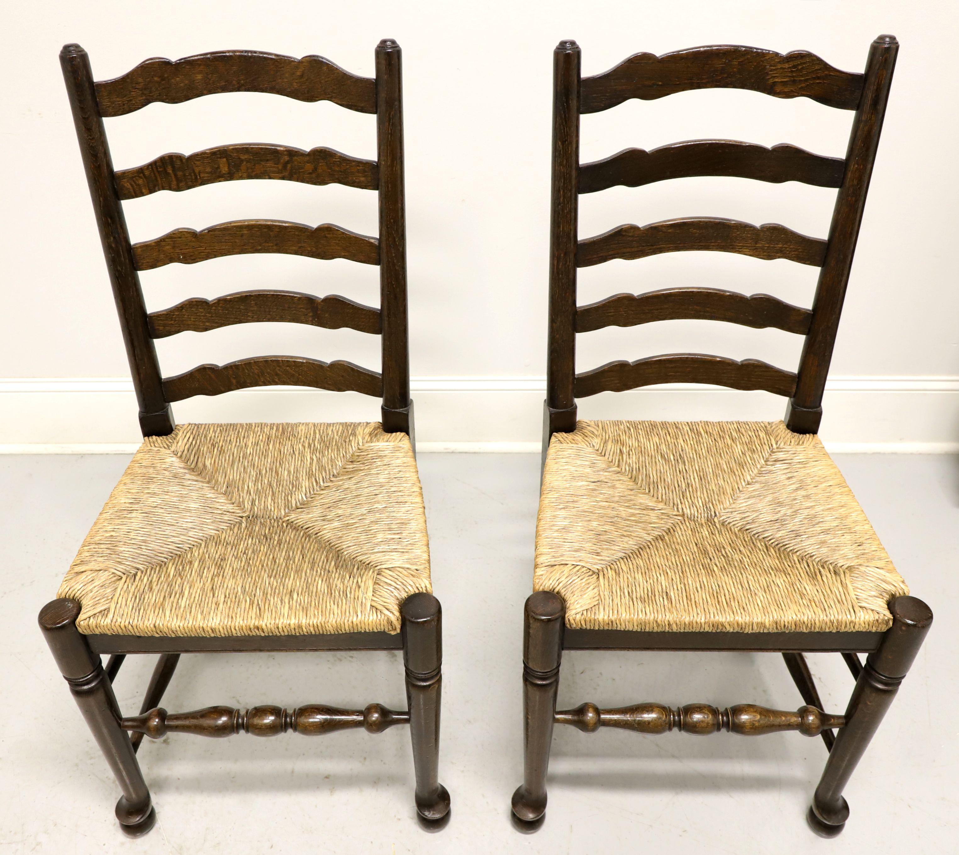 A pair of Cottage style dining side chairs, unbranded, similar in quality to Ethan Allen. Walnut with carved ladder back design, rush seats, turned legs and stretchers. Made in the USA, in the mid-20th century.

Measures: overall: 19W 18D 39.5H,