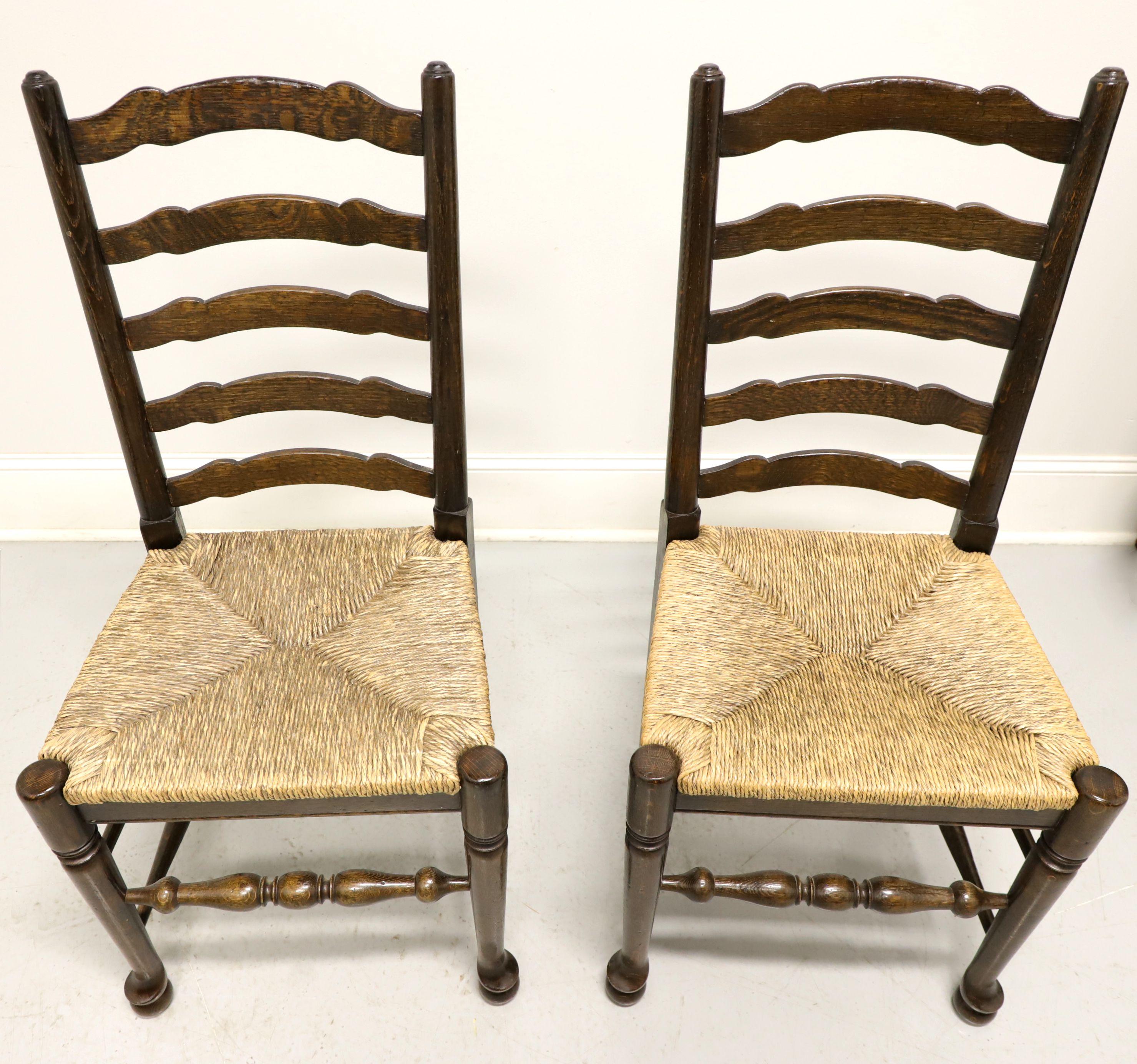 A pair of Cottage style dining side chairs, unbranded, similar in quality to Ethan Allen. Walnut with carved ladder back design, rush seats, turned legs and stretchers. Made in the USA, in the mid 20th Century.

Measures: Overall: 19w 18d 39.5h,