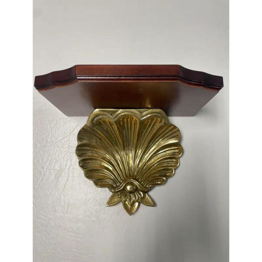 ONE absolutely GORGEOUS vintage Decorative Crafts Inc Brass Wall Sconce Shelf in excellent, well cared for condition! 

Gleaming lacquered brass clam or scallop shell with a varnished mahogany wood display shelf. Bracket rings on back for hanging.