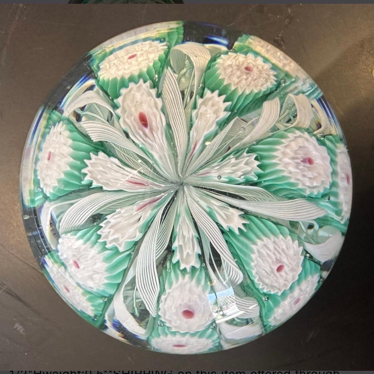 Beautiful Murano Paperweight with sticker still intact. This piece is exceptional with beautiful green and white spiral trellis with white millefori flowers with a pink center. 
Murano Fratelli Toso Glass
Murano millefiori 
91/4