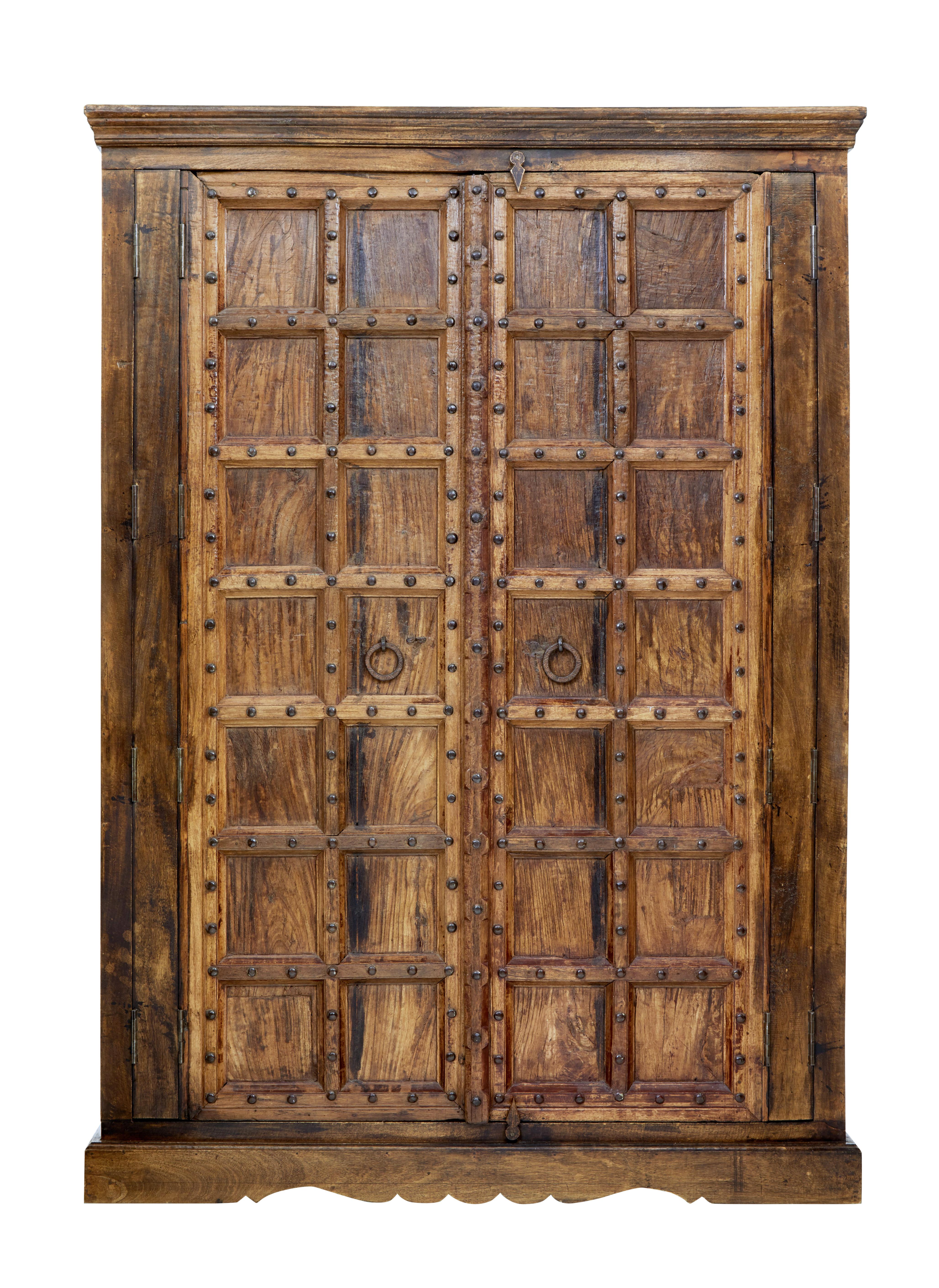 Beautiful imposing hardwood wardrobe, circa 1950.

With doors dating from the early 19th century this creates this atomospheric piece.

Heavy panelled doors with metal studwork and handles, opens to a two thirds hanging rail space and a 1 third