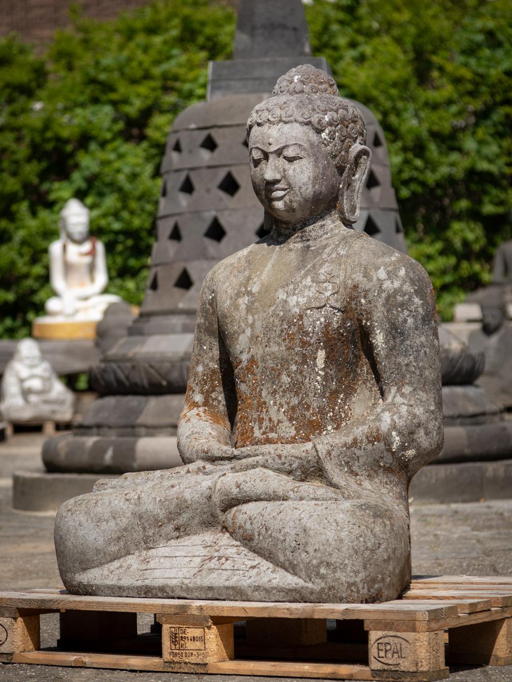 The large old lavastone Buddha statue is a captivating embodiment of spiritual artistry, skillfully carved from the enduring lavastone material. Standing at an impressive height of 121 cm, with dimensions of 86 cm in width and 62 cm in depth, its
