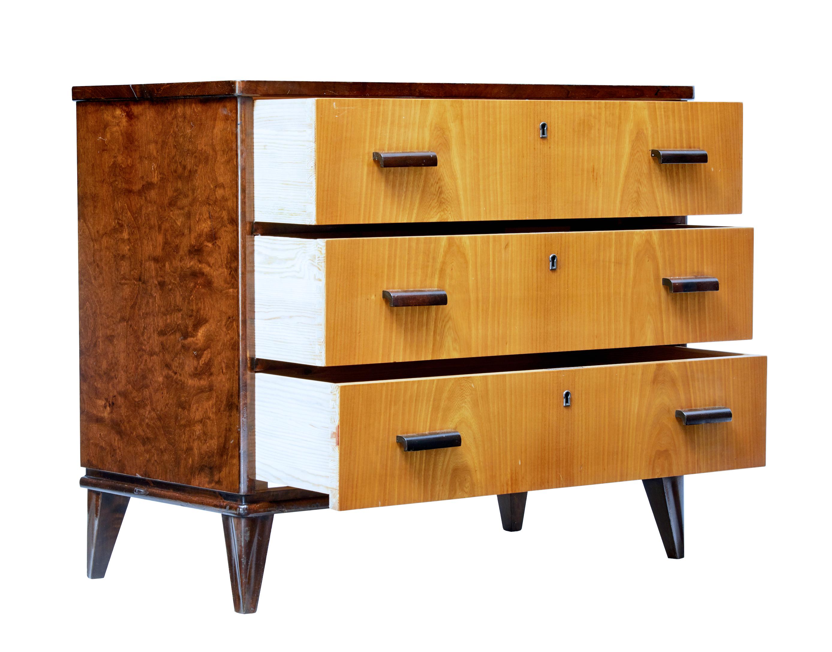 Good quality late art deco chest of drawers, circa 1940.

3 drawers with golden elm veneer which provides a striking contrast to the dark stained birch frame. Shaped wooden handles to the drawer fronts.

Burr birch sides and top surface. Pine