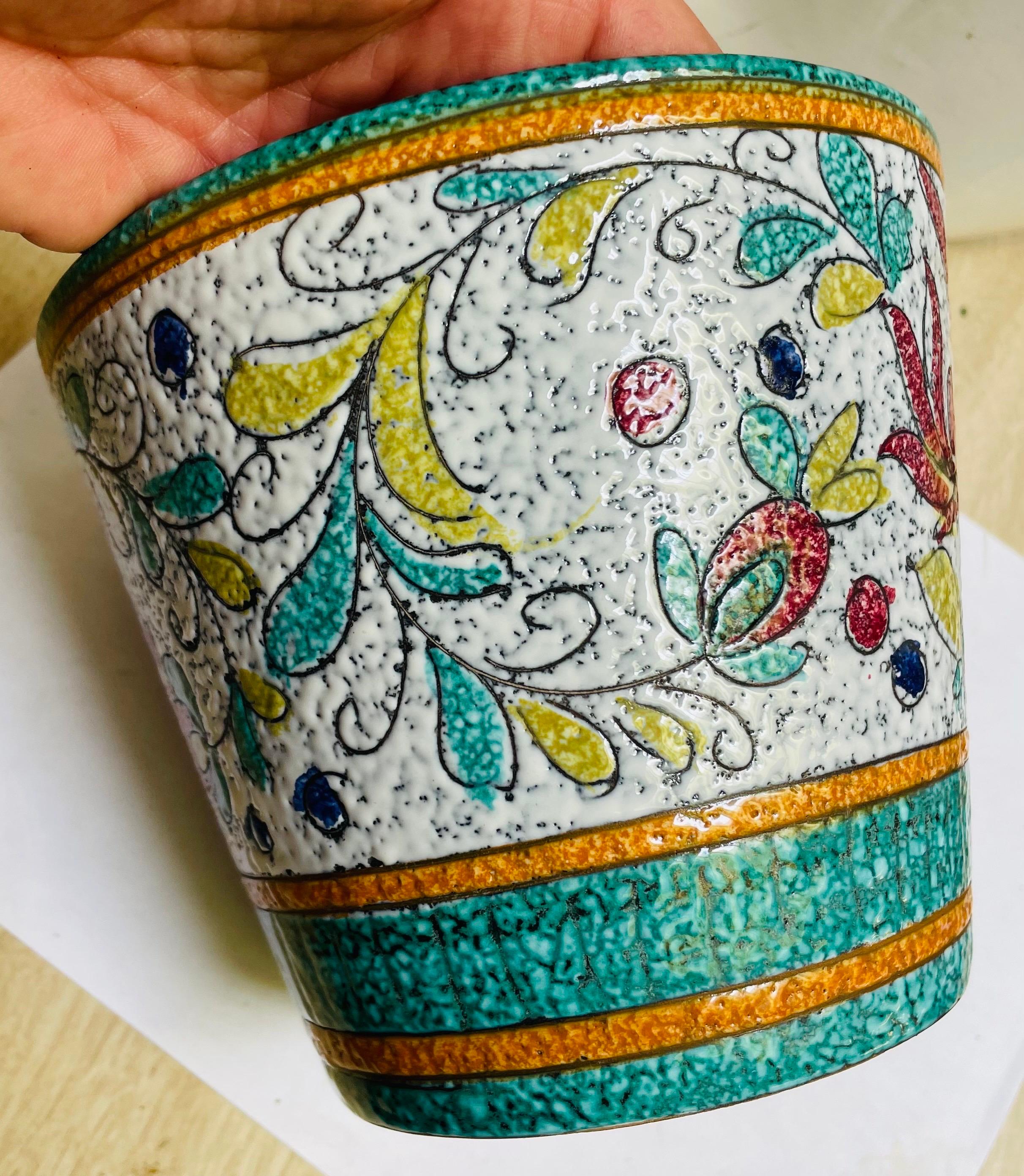 This is a colorful Italian pot with a modern mottled lava glaze finish. The pot was probably intended to hold a plant but would be interesting as an ice bucket, cachepot or just a nice splash of color. The teal, mustard, orange, white and two shades
